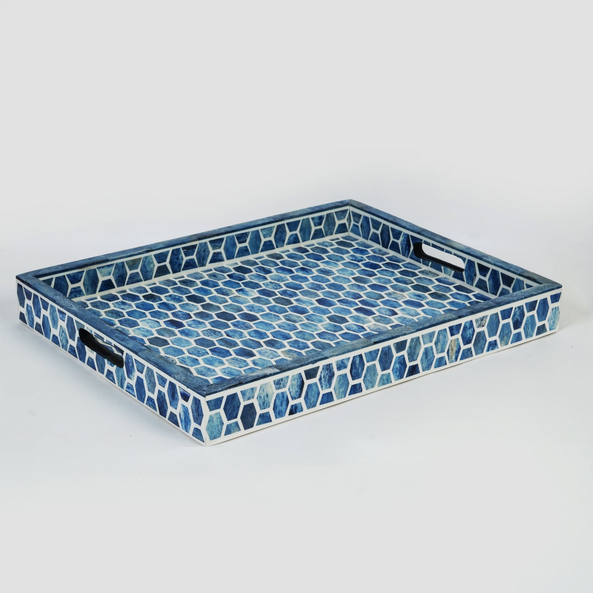 A close-up of nesting blue bone inlay trays showing the smooth, hand-polished finish and built-in handles.