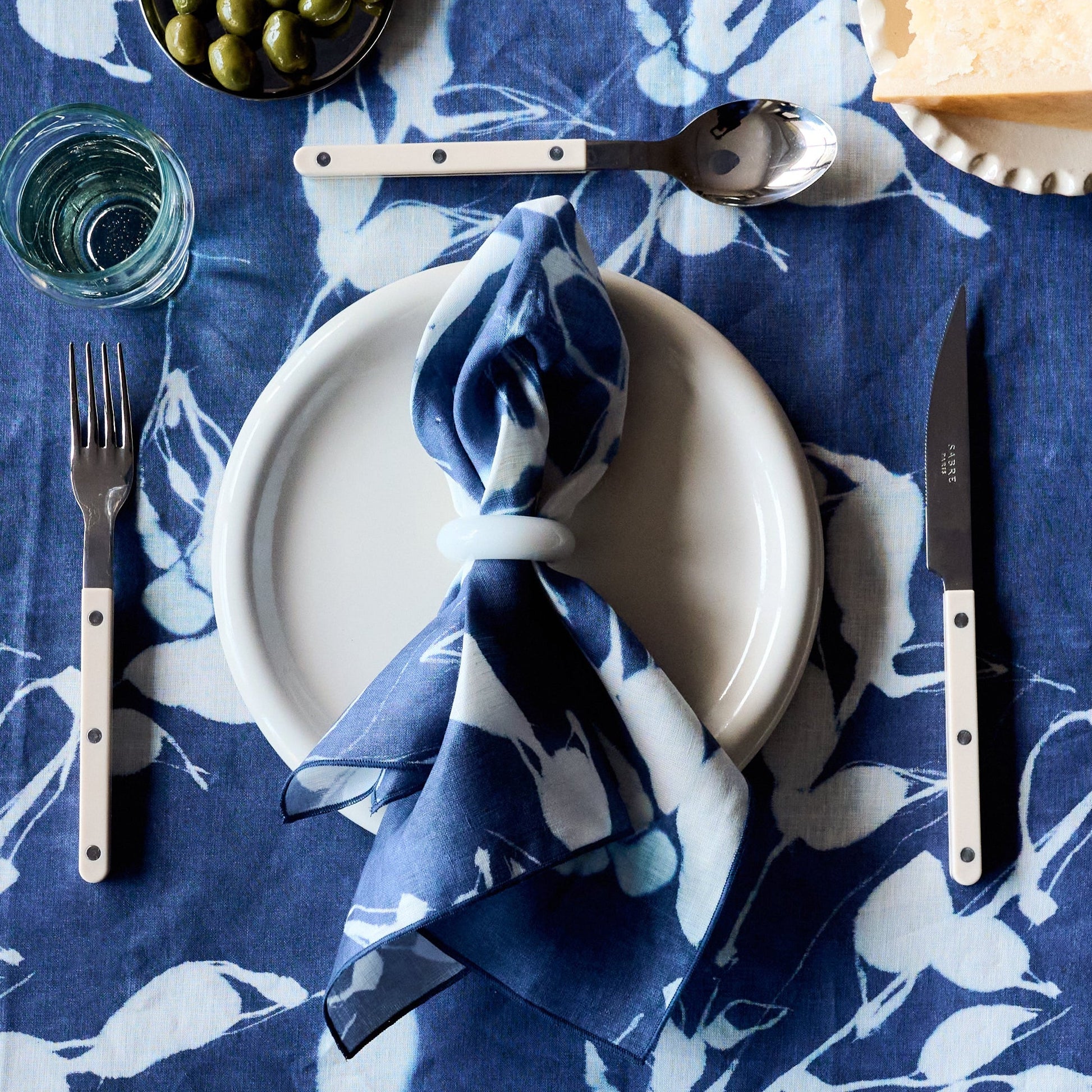 Porto Print Indigo linen dinner napkin with hand-painted vineyard-inspired floral pattern in deep indigo blue - Goldie Home
