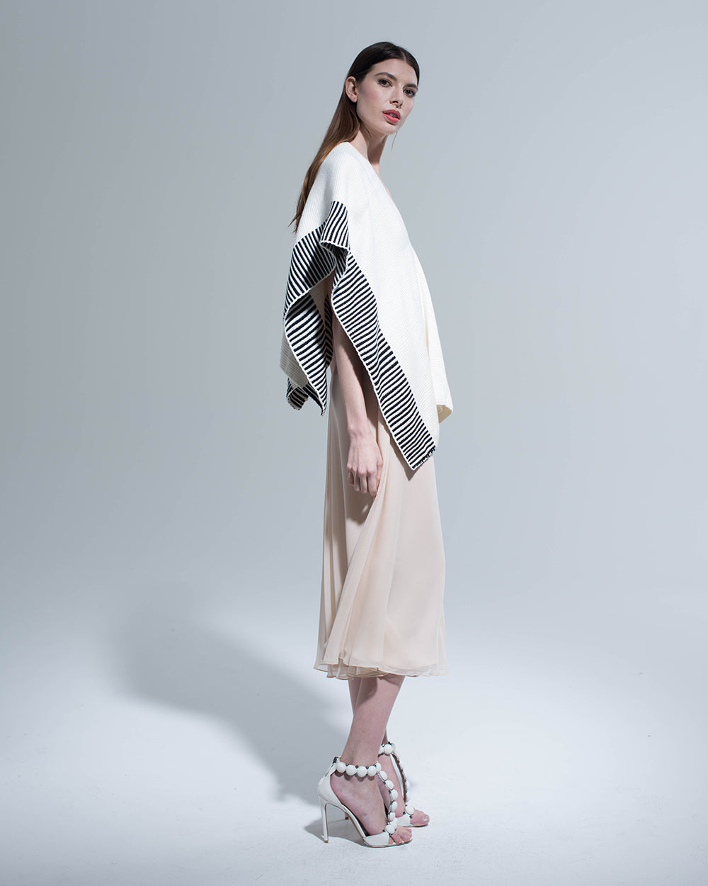 Model wearing Striped Edge Cotton Manta in cream and black, side view