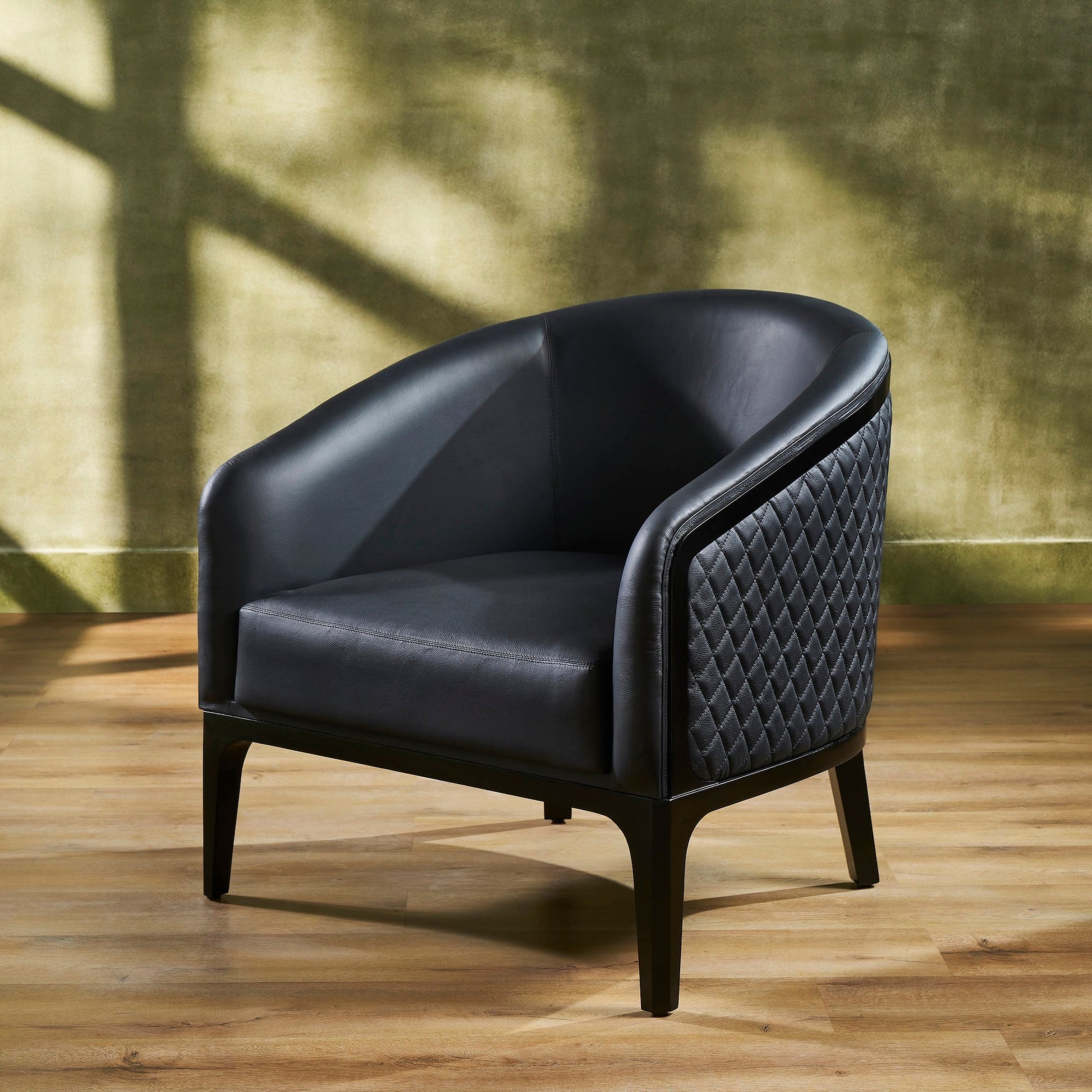 FN-5205-343329_2|Stylish black leather armchair featuring elegant quilted side detailing and sturdy dark wood legs, perfect for luxury living room decor.
