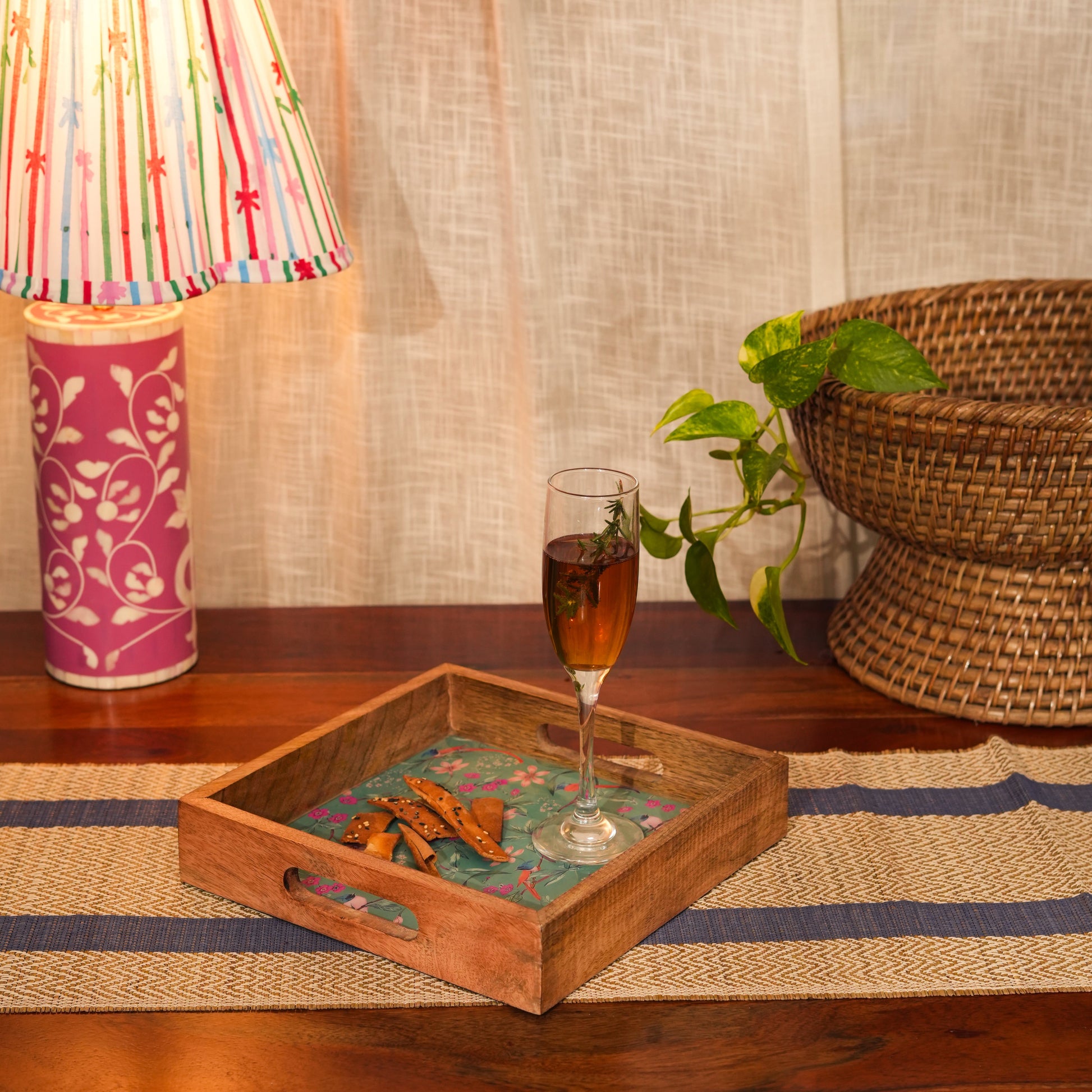 Handcrafted floral tray styled on a patio table with a glass of wine and summer decor.