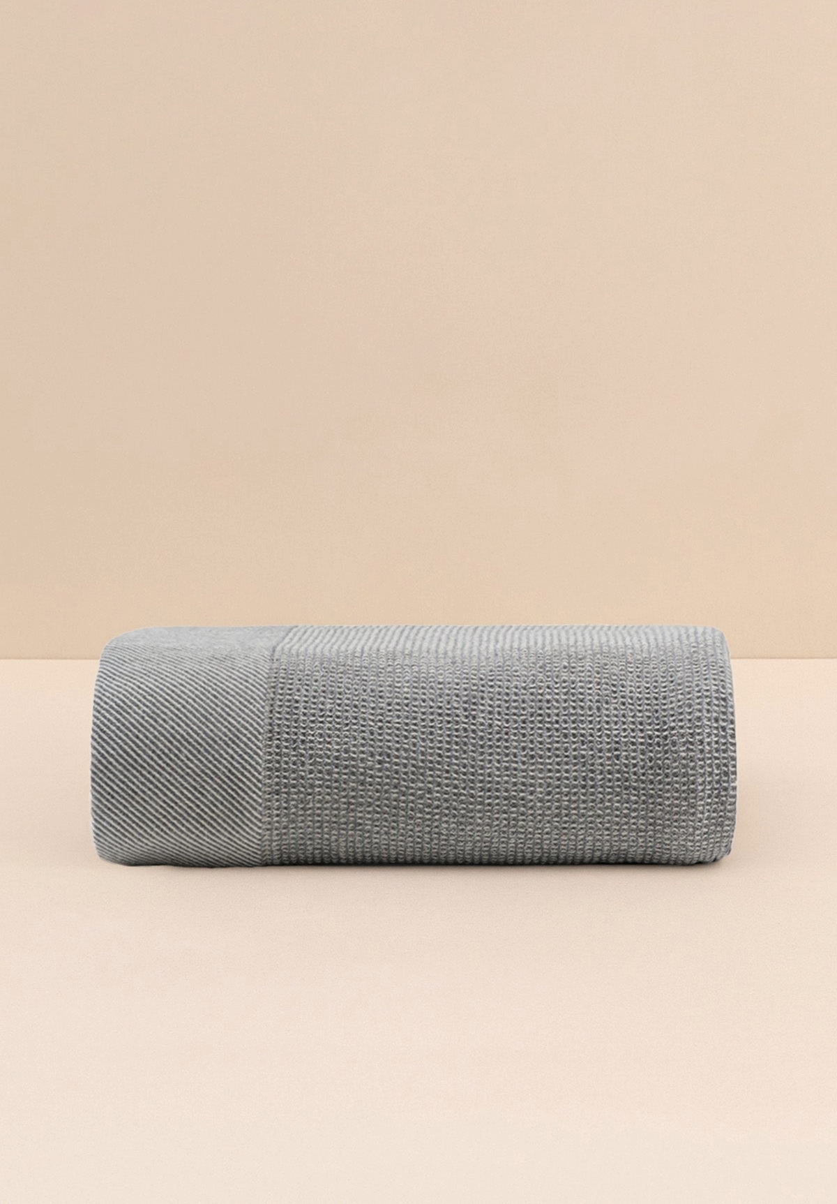 Gray textured throw blanket on a beige background
