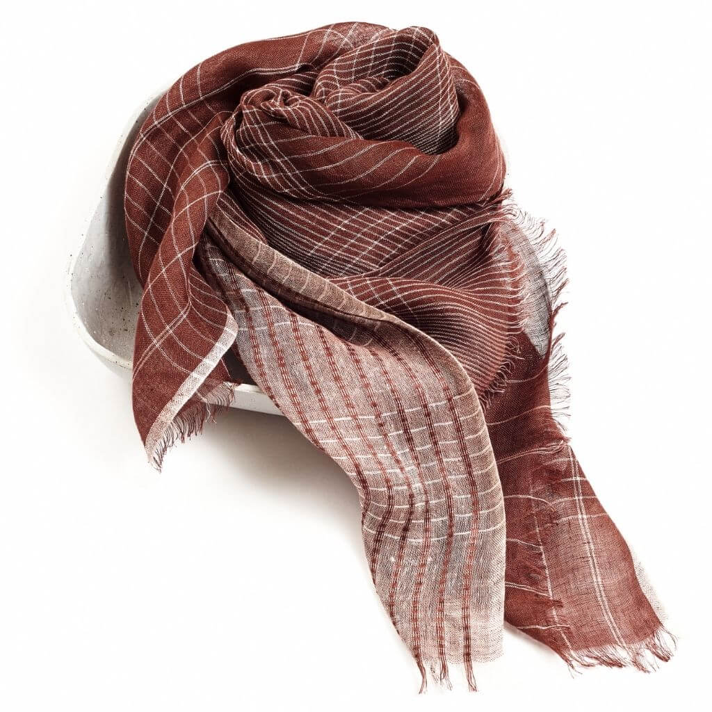 Auro Cinnabar Handwoven Earthy Rust Maroon Linen Scarf displayed elegantly in a bowl, showcasing its unique textures and patterns.