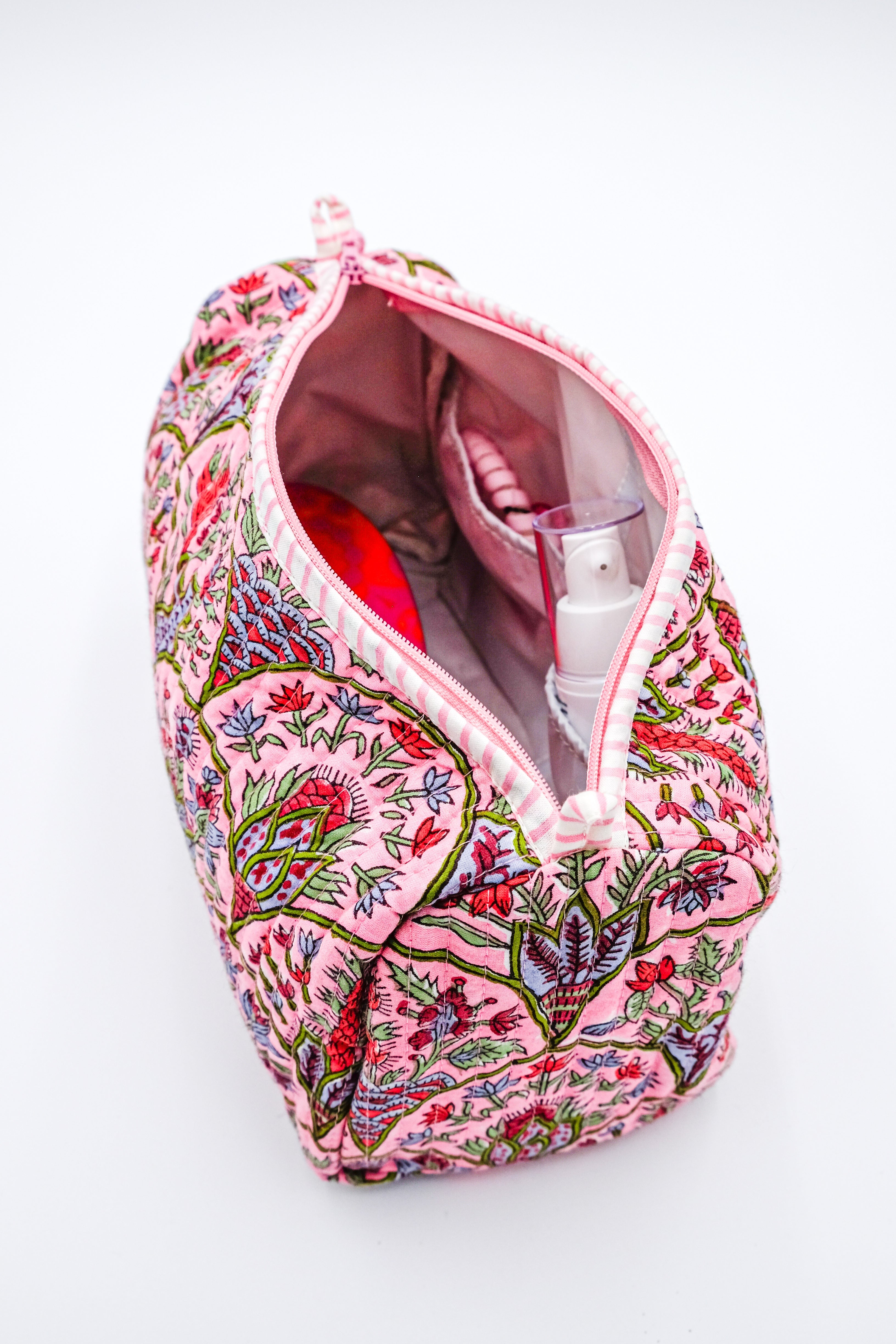 Open pink Arch toiletry bag showing interior with toiletries