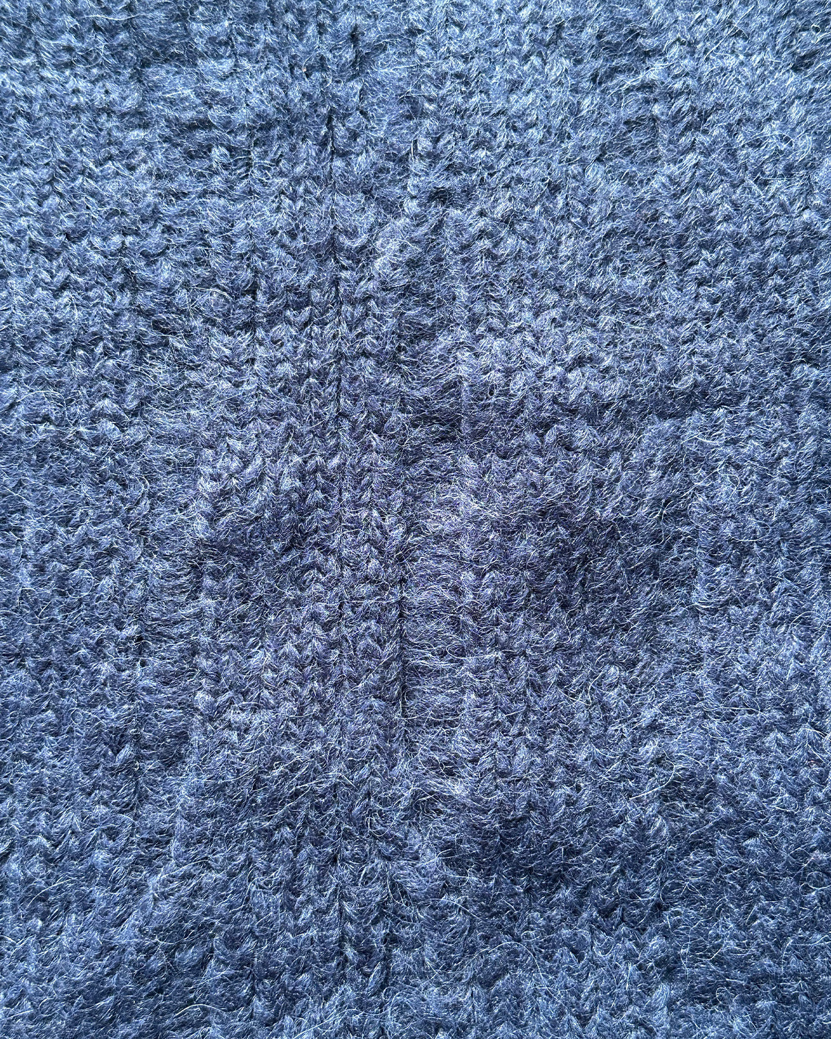 Close-up of textured navy ribbed fabric of a cropped sweater
