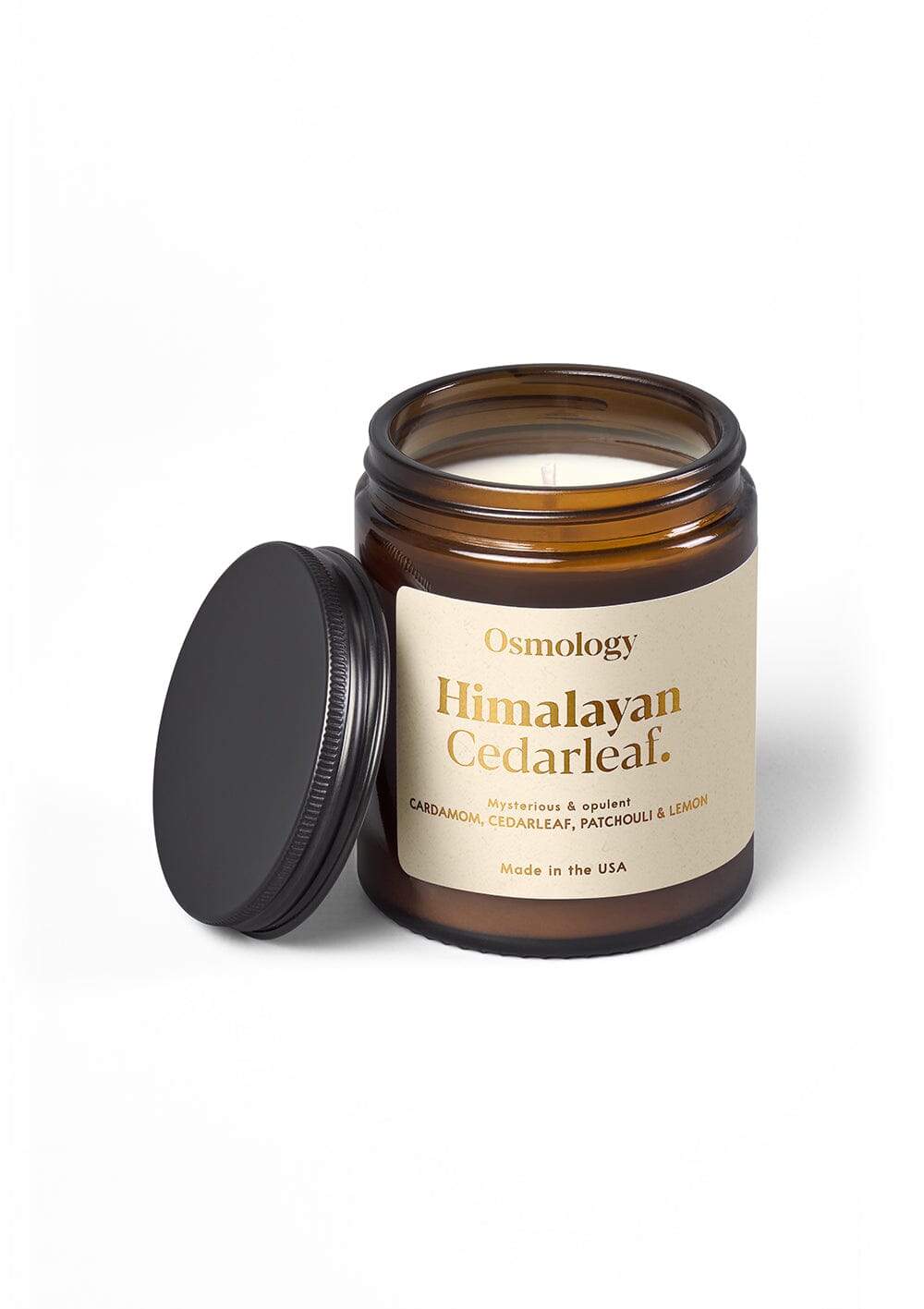 Osmology Himalayan Cedarleaf jar candle with open lid, on cream background