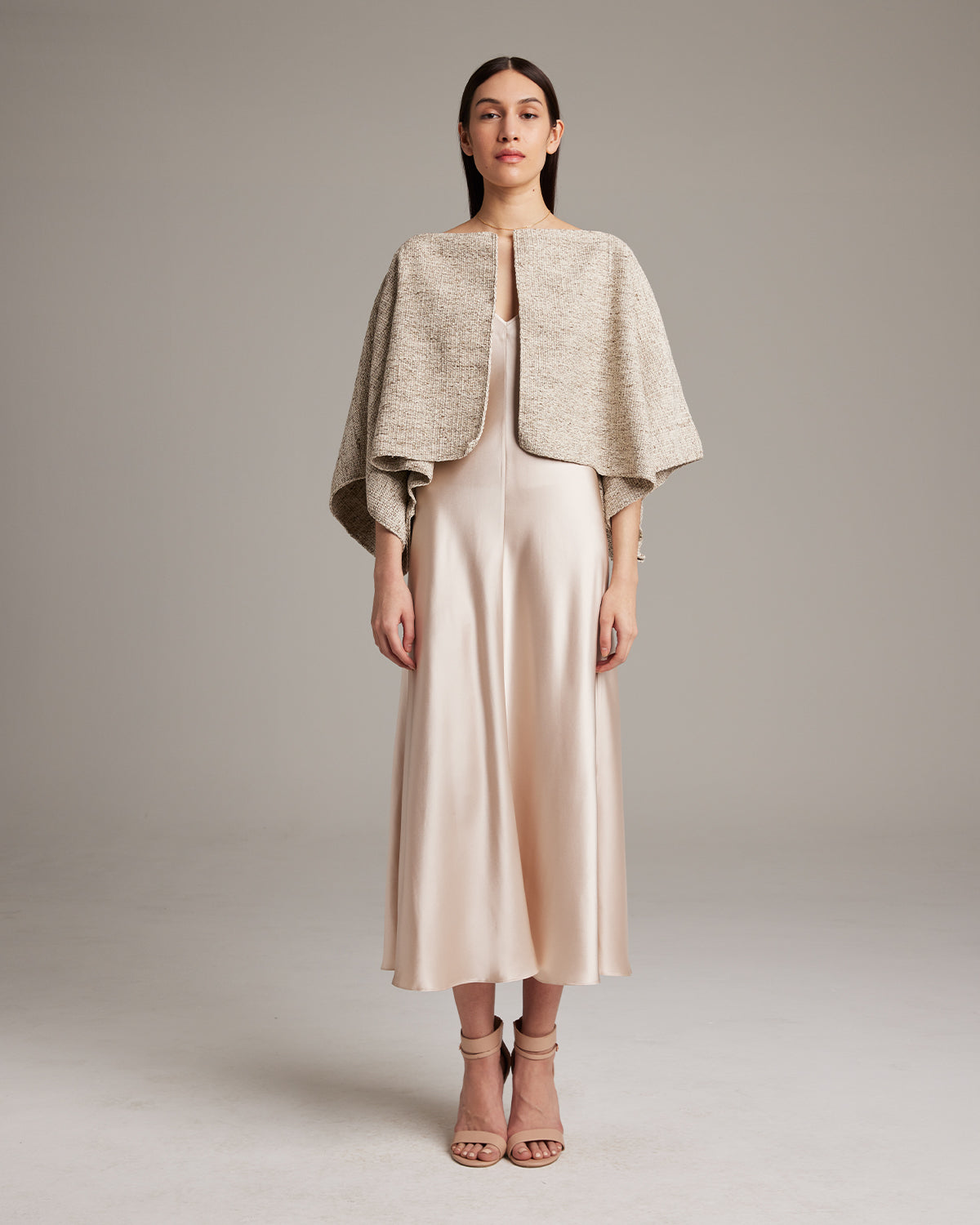 Model wearing a beige Marble Bolero over a satin dress