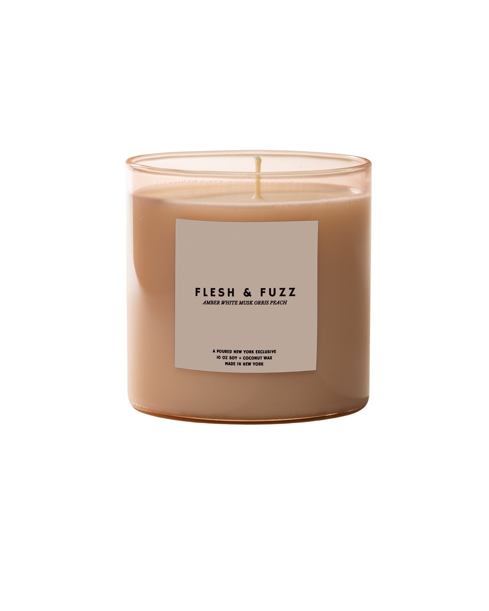 Candle labeled 'Flesh & Fuzz' with a matching box on a neutral background
