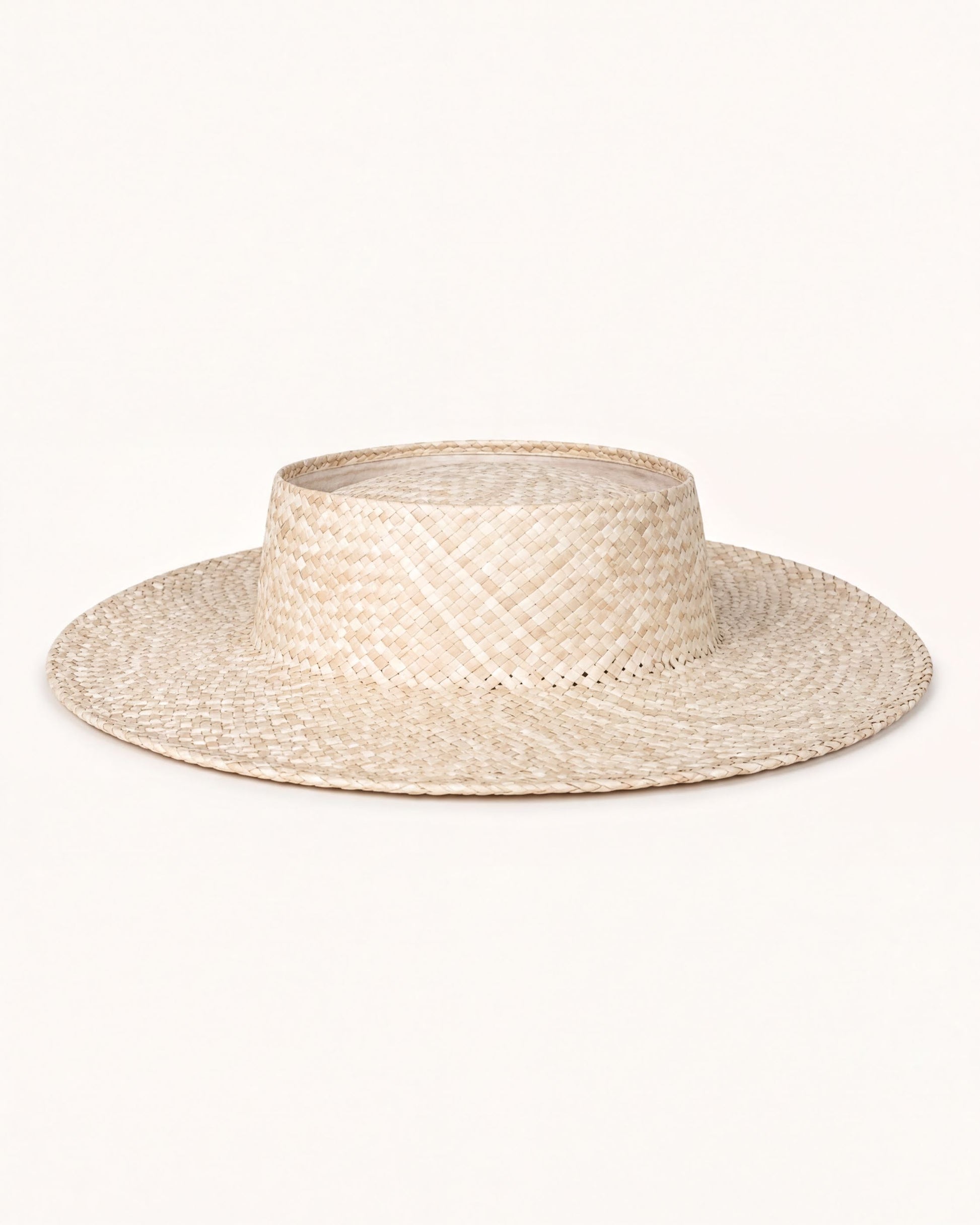 A straw hat with a wide brim and a round crown, sitting on a plain white background.