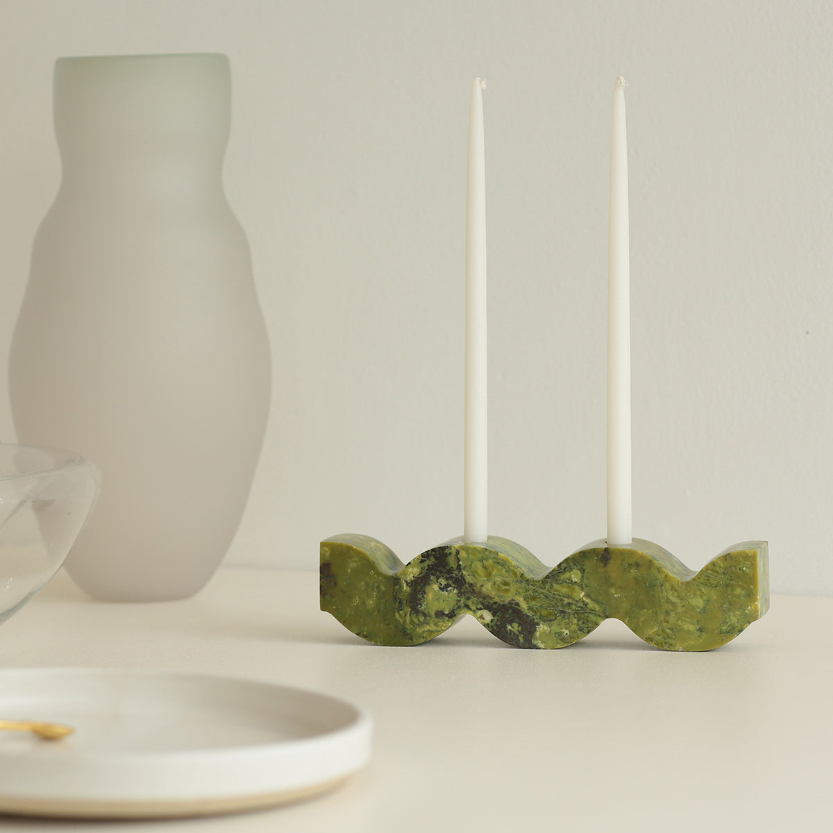 Decorative serpentine green wavy candelabra highlighting natural Andean stone veins on a white background.