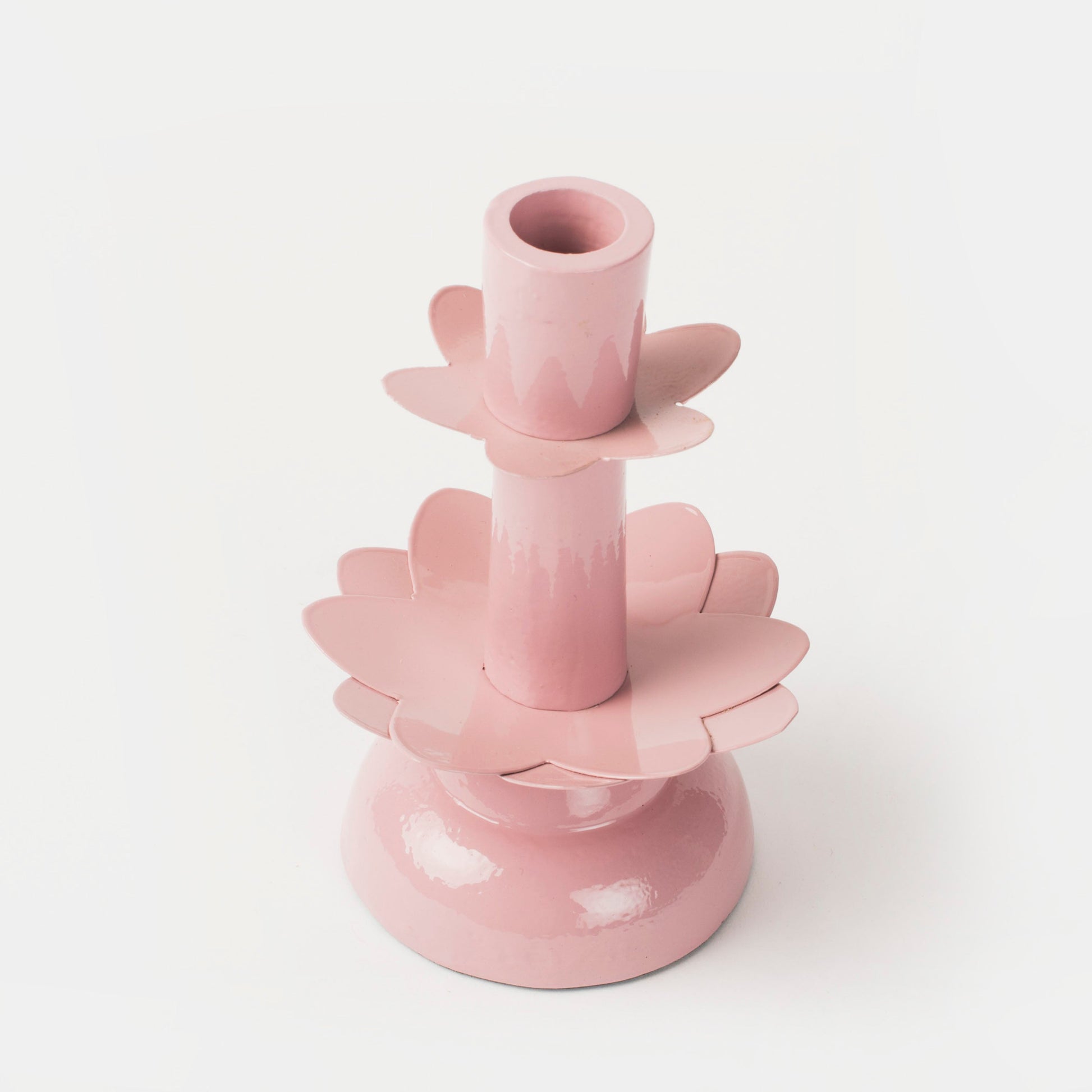 Close-up of the smooth, matte pink finish on a handcrafted floral-shaped candlestick holder.