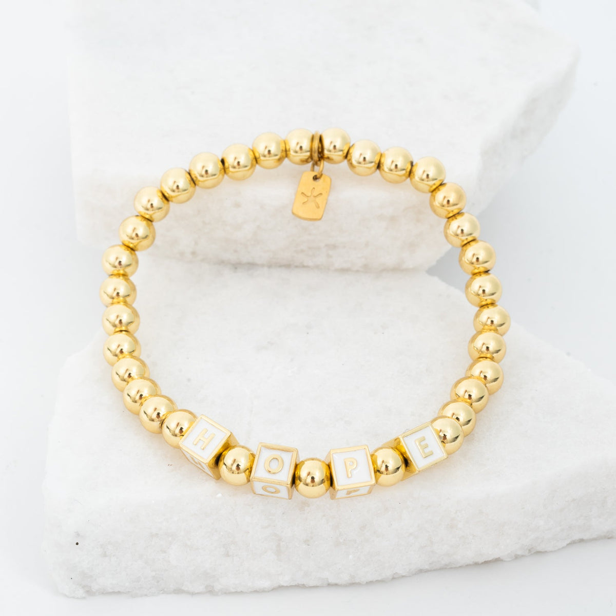 Photo of gold beaded bracelet, gold "hope" message, gold brass beads, symbol of hope, jewelry company like pandora