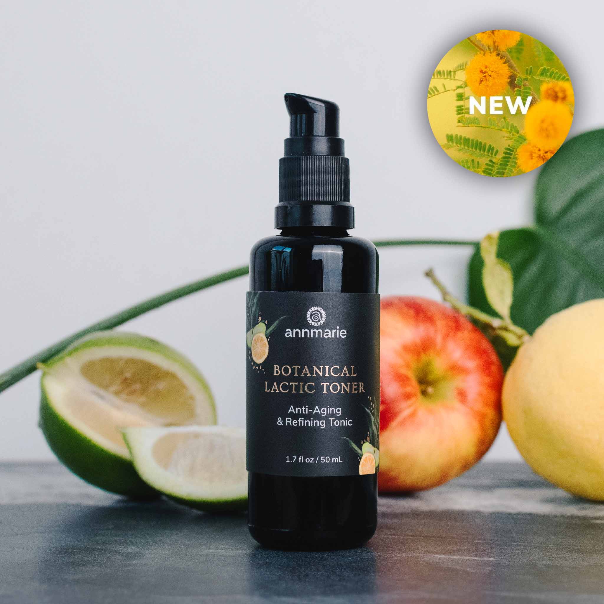 Black bottle of Botanical Lactic Toner by Annmarie with fruits and leaves on a light background