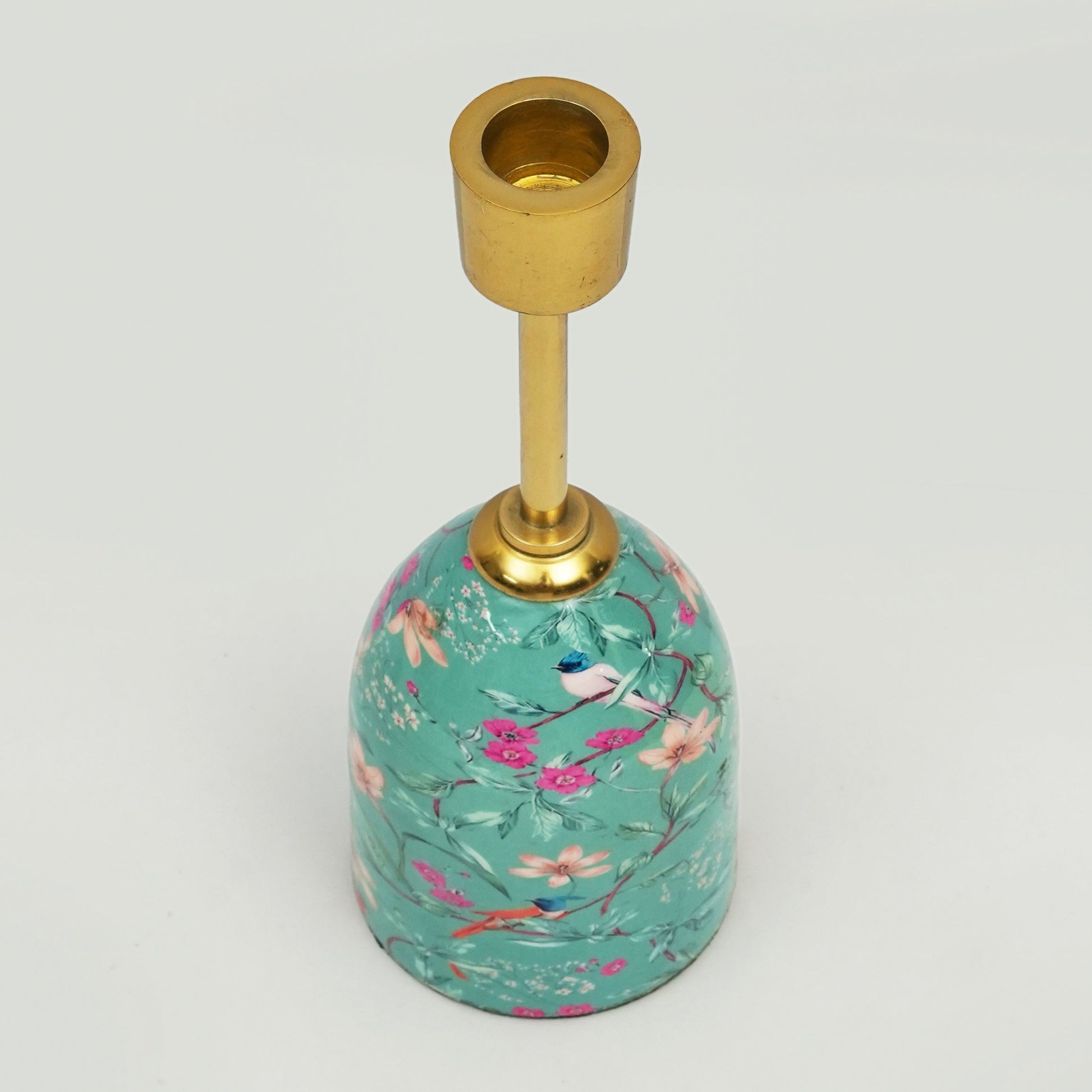 Decorative candle holder with floral design and gold accent on a white background