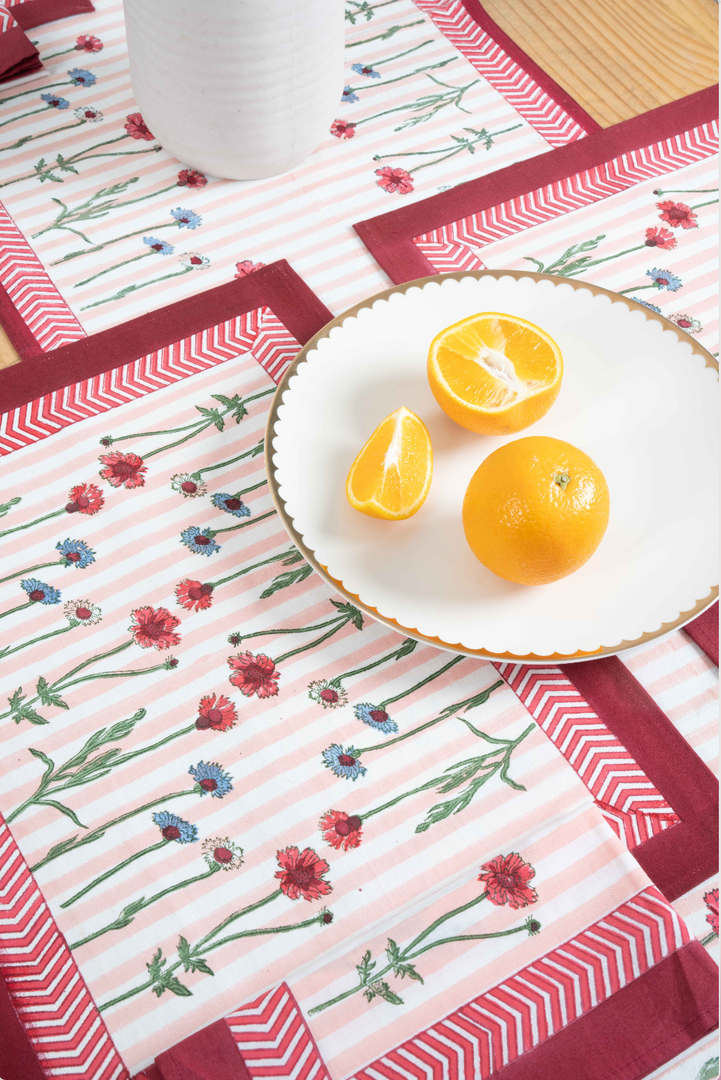 Wildflower blockprint placemats with red chevron borders, orange plate, Inner Child design