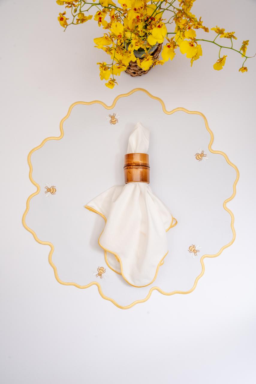 Bumble bee impermeable placemat with hand-stitched bee embroidery and yellow wavy border by Talah Home