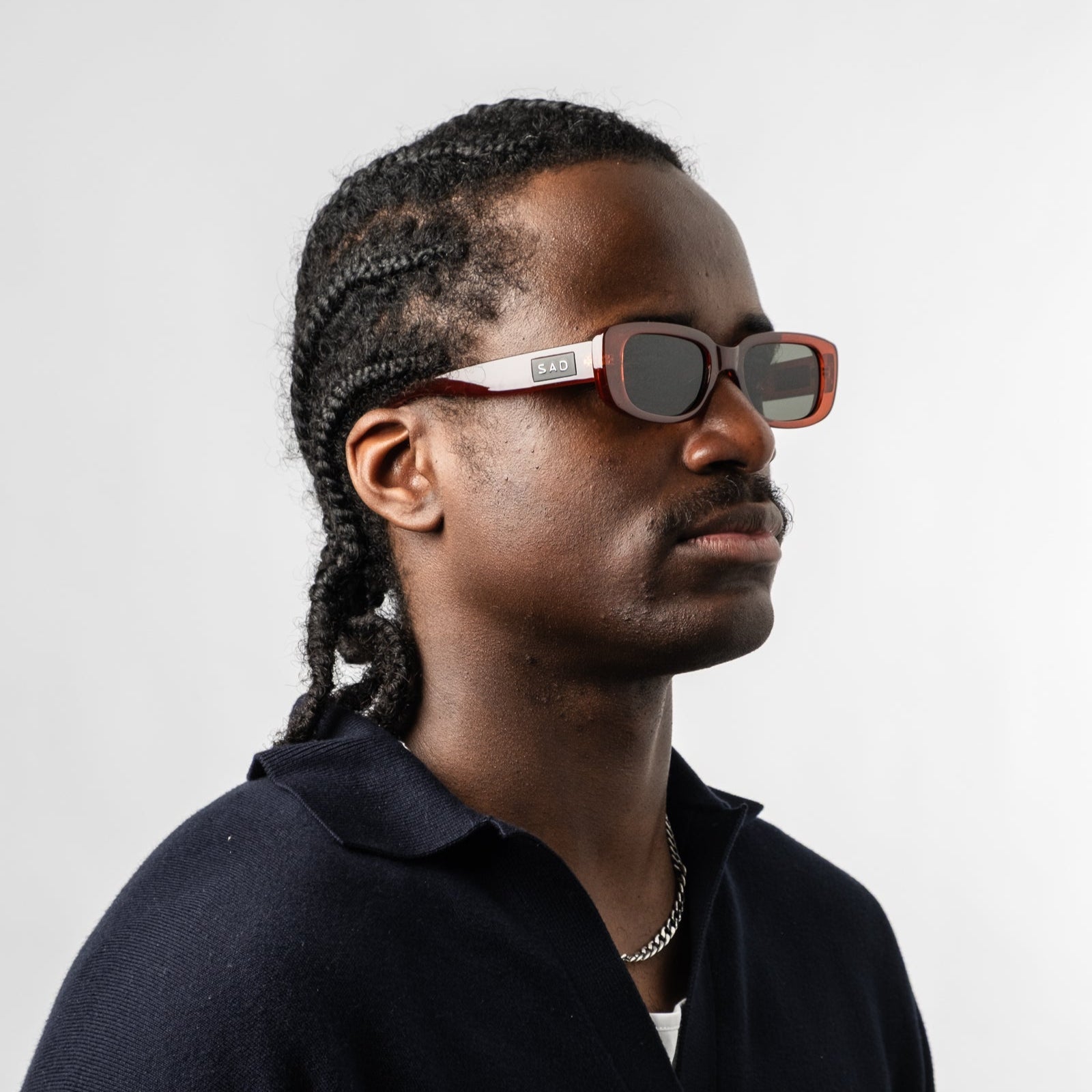 Male wearing Sad Eyewear Bouquet rectangle sunglasses in blood red with black tinted lenses