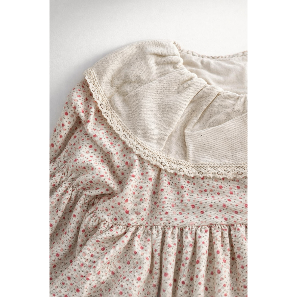 Close-up of a floral dress with lace trim on a white background