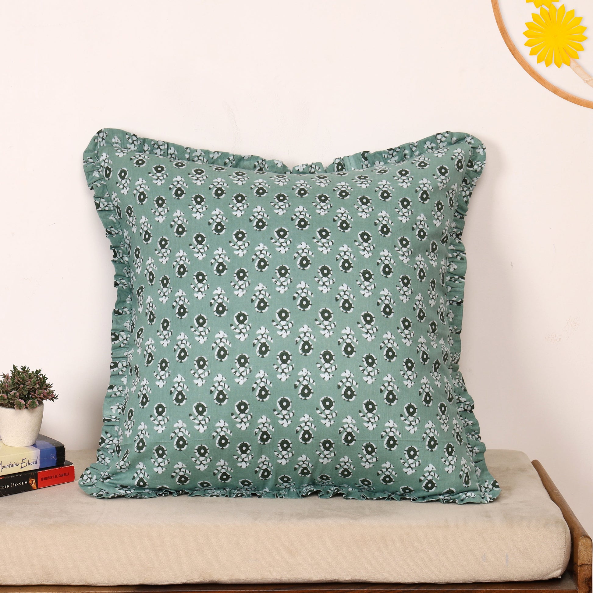 Teal block-printed ruffled pillow cover on cushion