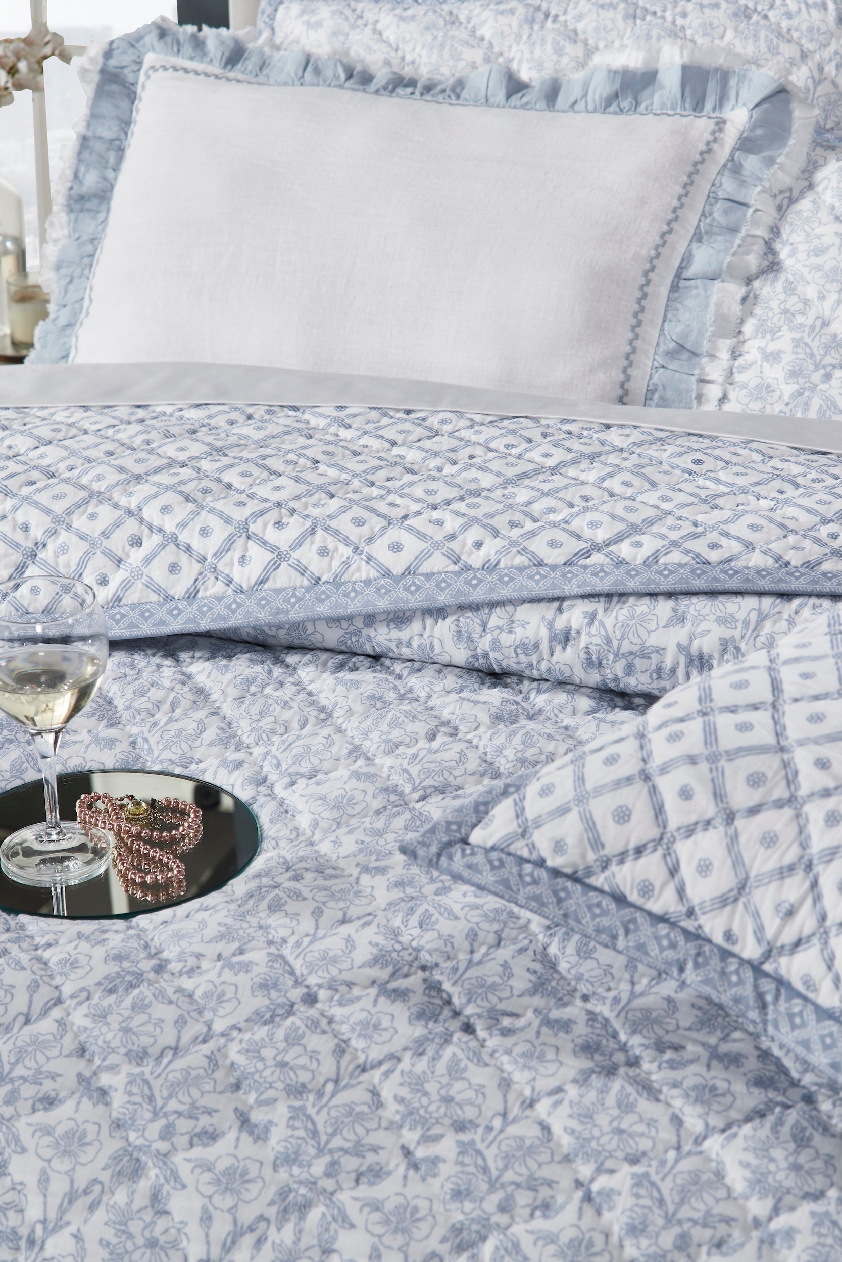 QT-345-11096_5|Close-up of light blue patterned quilt with diamond stitching, featuring elegant floral and geometric designs.