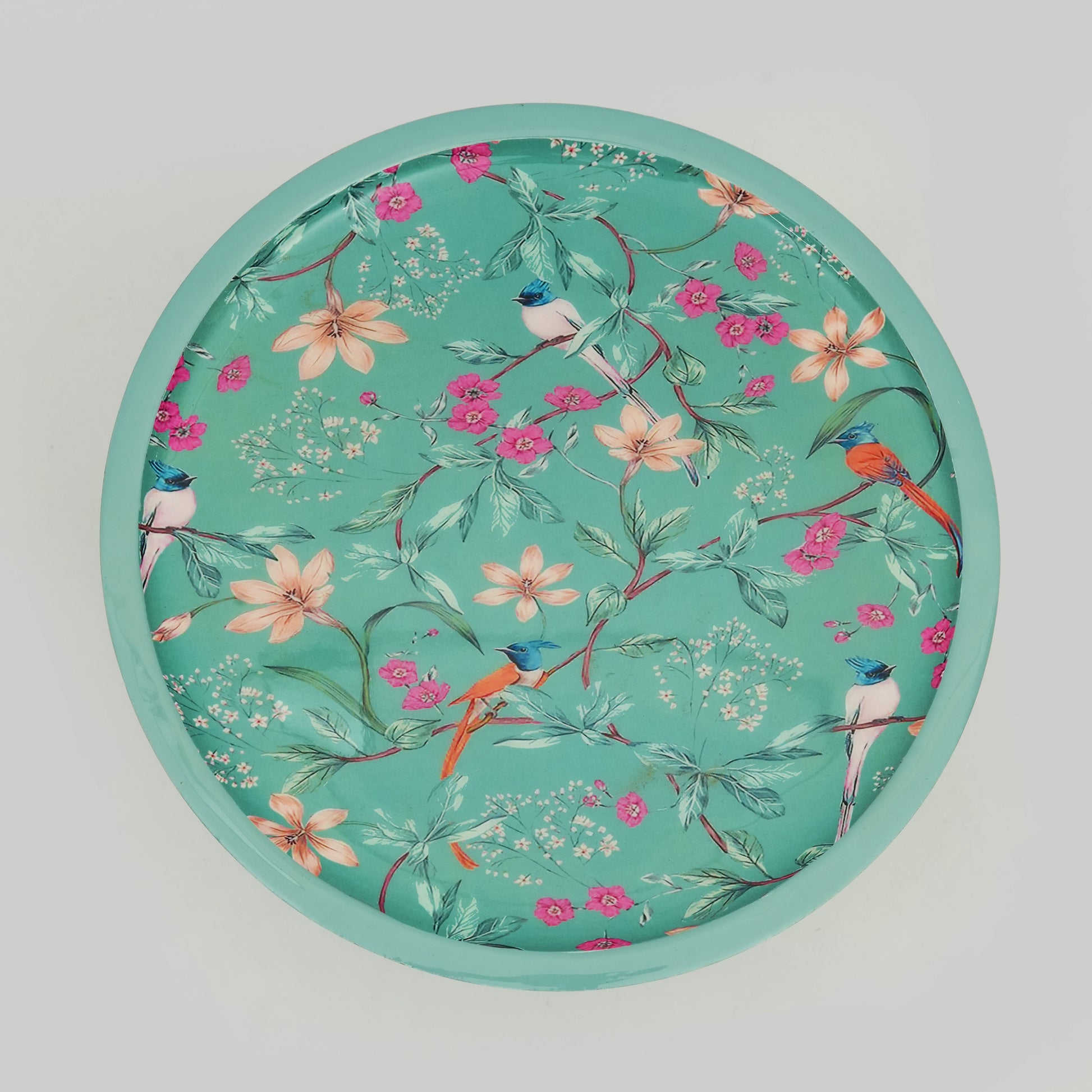 Macro view of the vibrant bird and floral motif on the Aqua Flora serveware collection.