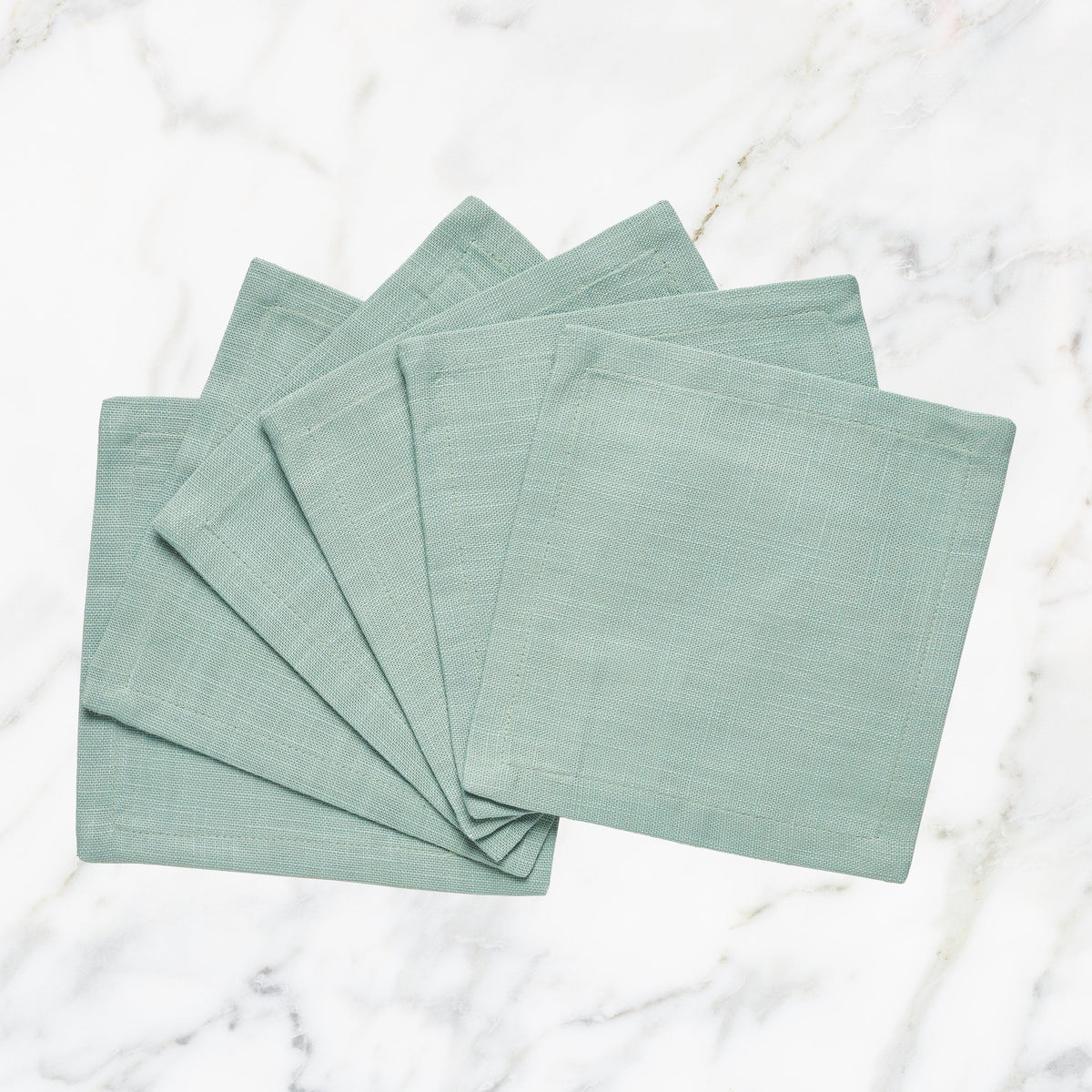 CNP-4911-66_1|Set of fan-folded mint green linen dinner napkins on marble, perfect for stylish dining, reusable, modern table decor.