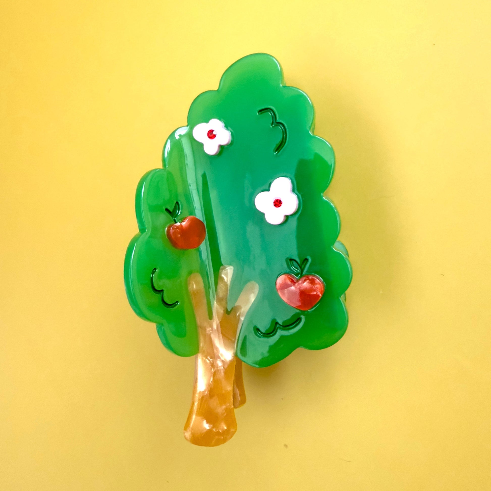 Imagine a Centinelle apple tree hair claw, its green branches reaching out like welcoming arms, adorned with blossoms in delicate shades of pink and red, filling the air with a sweet, enchanting perfume. 

As the seasons dance by, those blossoms mature into plump, ruby-red apples, glistening in the sun, a vibrant celebration of nature's bounty, ready to help you keep that hair bun in place.