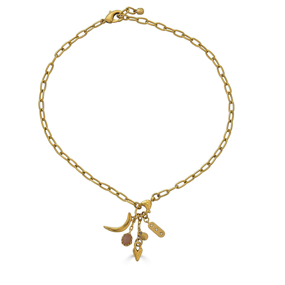 Gold necklace featuring a peach moonstone drop and charm cluster with crescent moon and heart details.