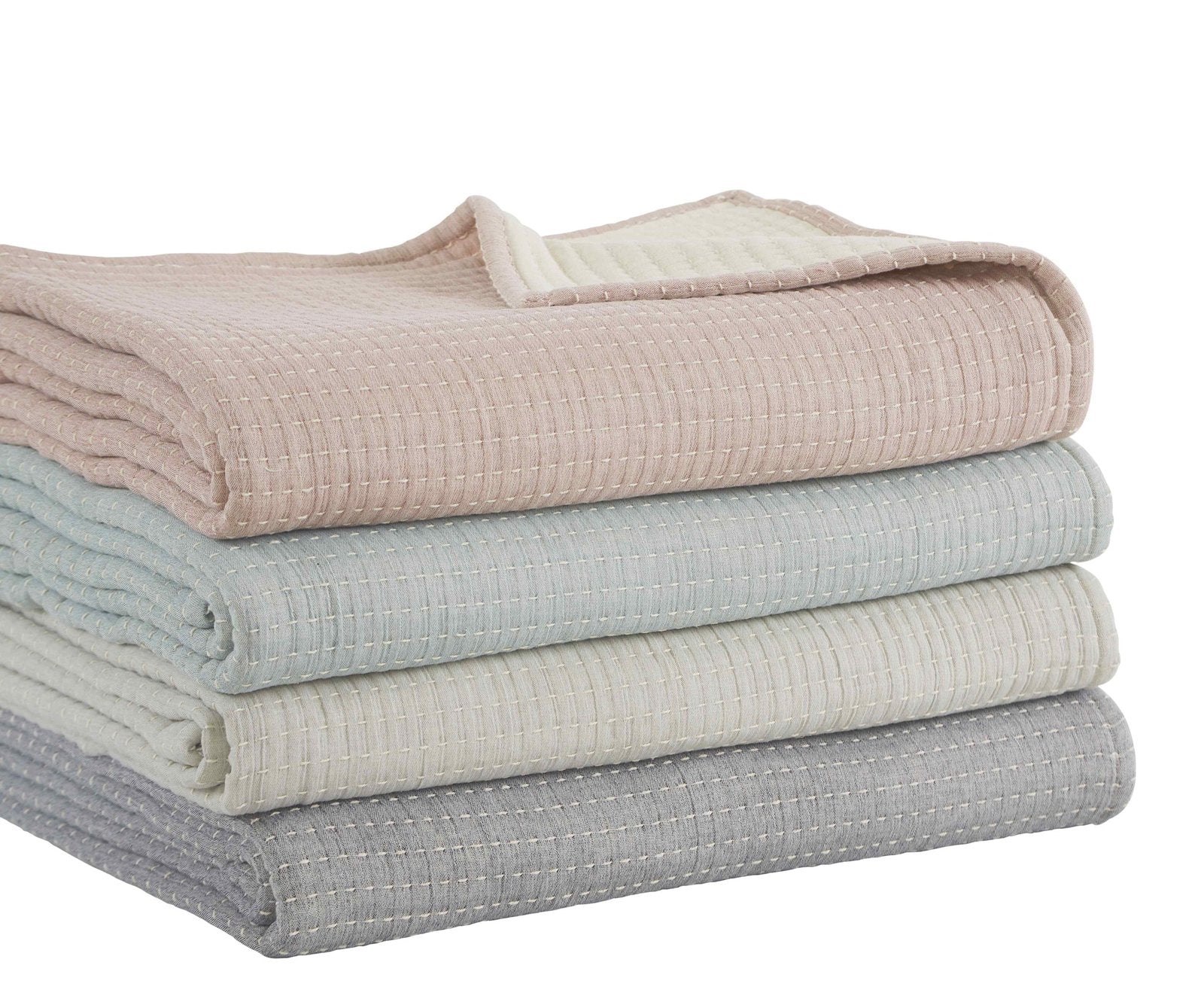 BT-107-11096_2|Stack of four folded textured reversible quilt blankets: soft pink, tranquil blue, creamy white, and neutral grey for varied bedding.