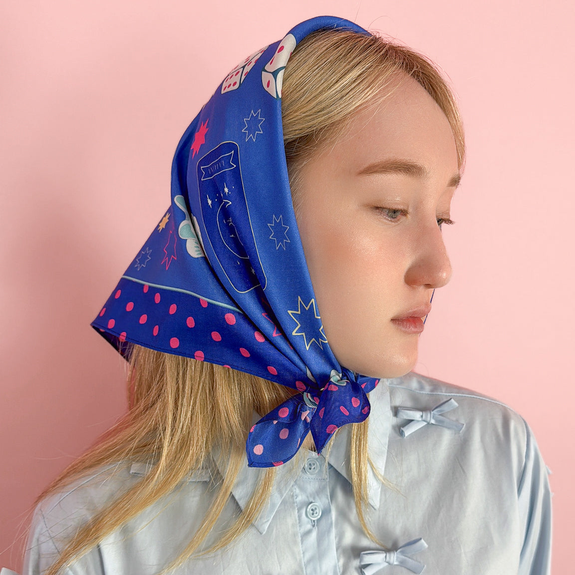 Fortune cotton silk bandana on blue, with white and hot pink touches, is full of lucky charms, maneki cat, tarot card, black cat, crossing fingers, dice and more, can be worn as a head scarf , neckerchief or to decorate your tote bag.  Made of a luxurious cotton-silk blend with a precise machine-stitched hemming, perfect as head wraps or neckerchiefs, bandana hairstyles, bandana headband; bandana style is in and now. Ethically sourced.