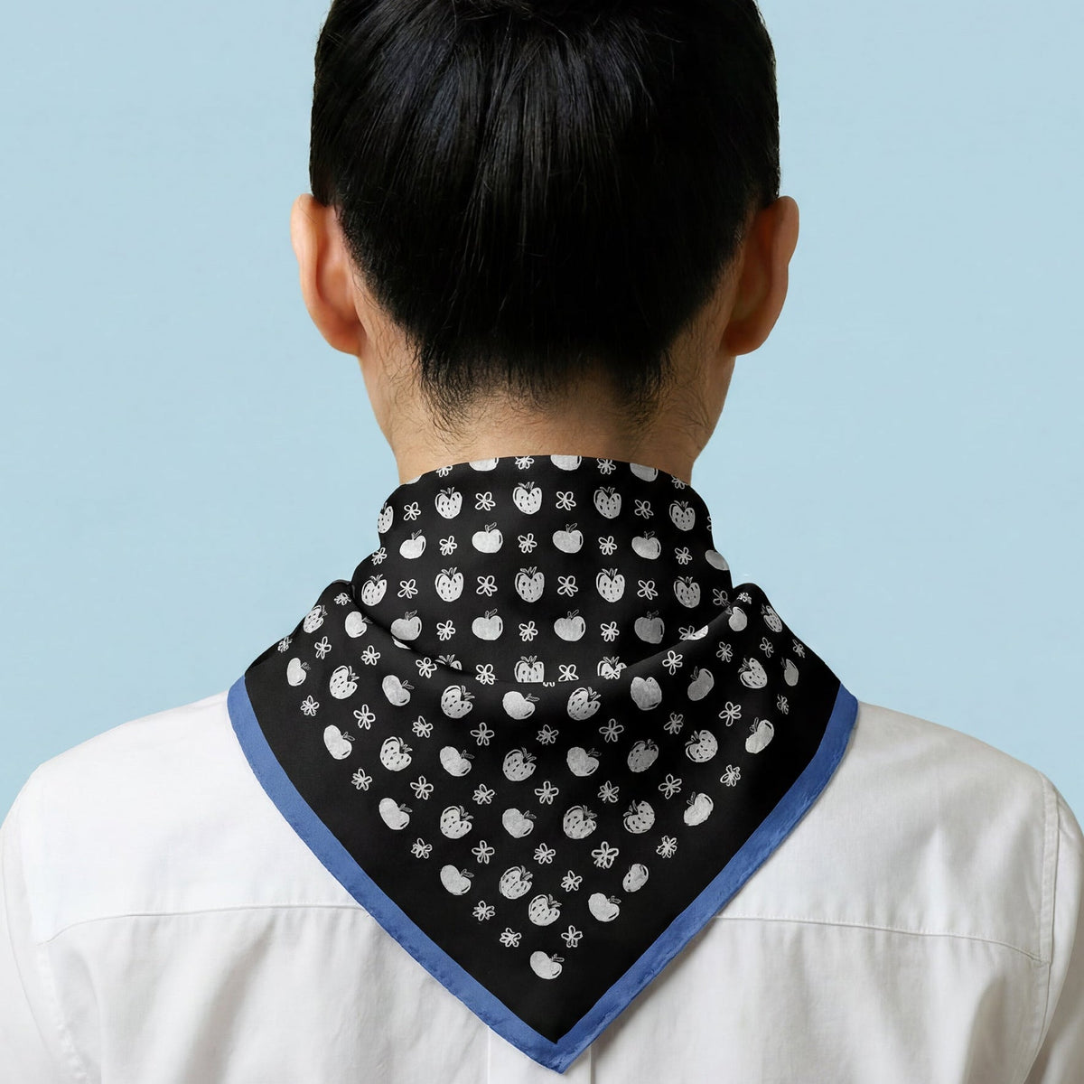 Person wearing a black and white patterned bandana on a light blue background