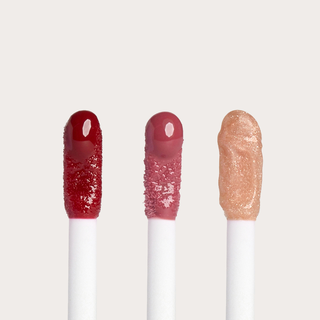 Open applicators of Côte Beauty The Sirens Lip Trio Peptide Non-Toxic Lip Gloss Set in, Berry, Mauve and Nude shades. 