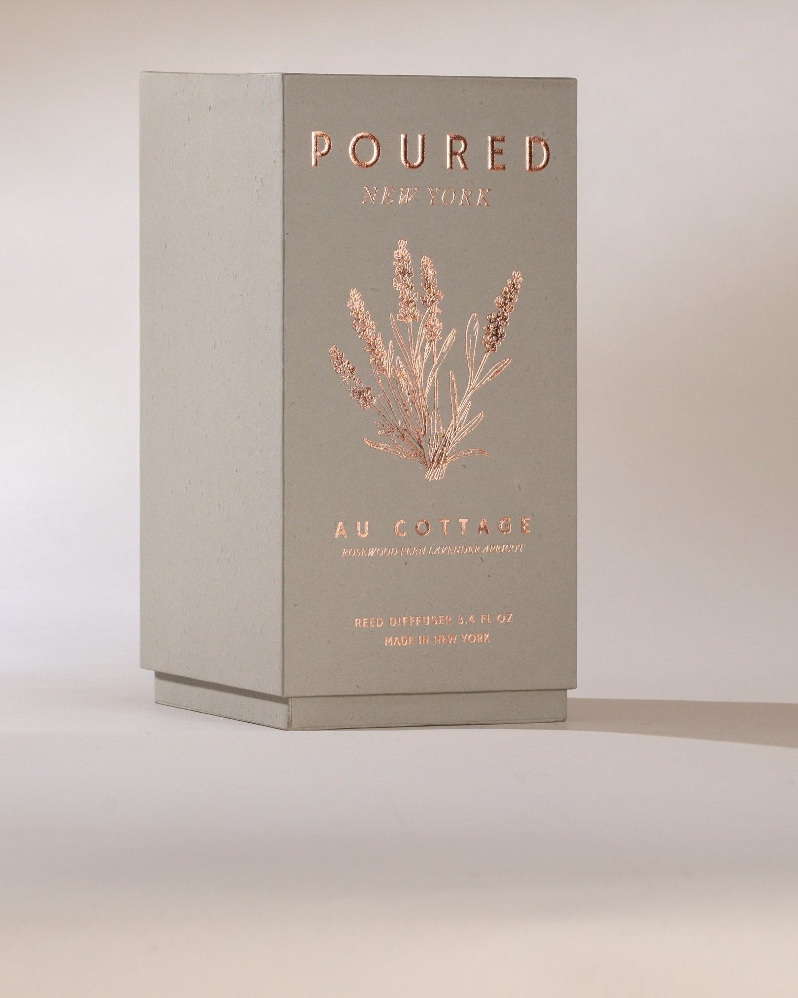 Poured New York 'Au Cottage' grey reed diffuser box and lavender decal on a neutral background