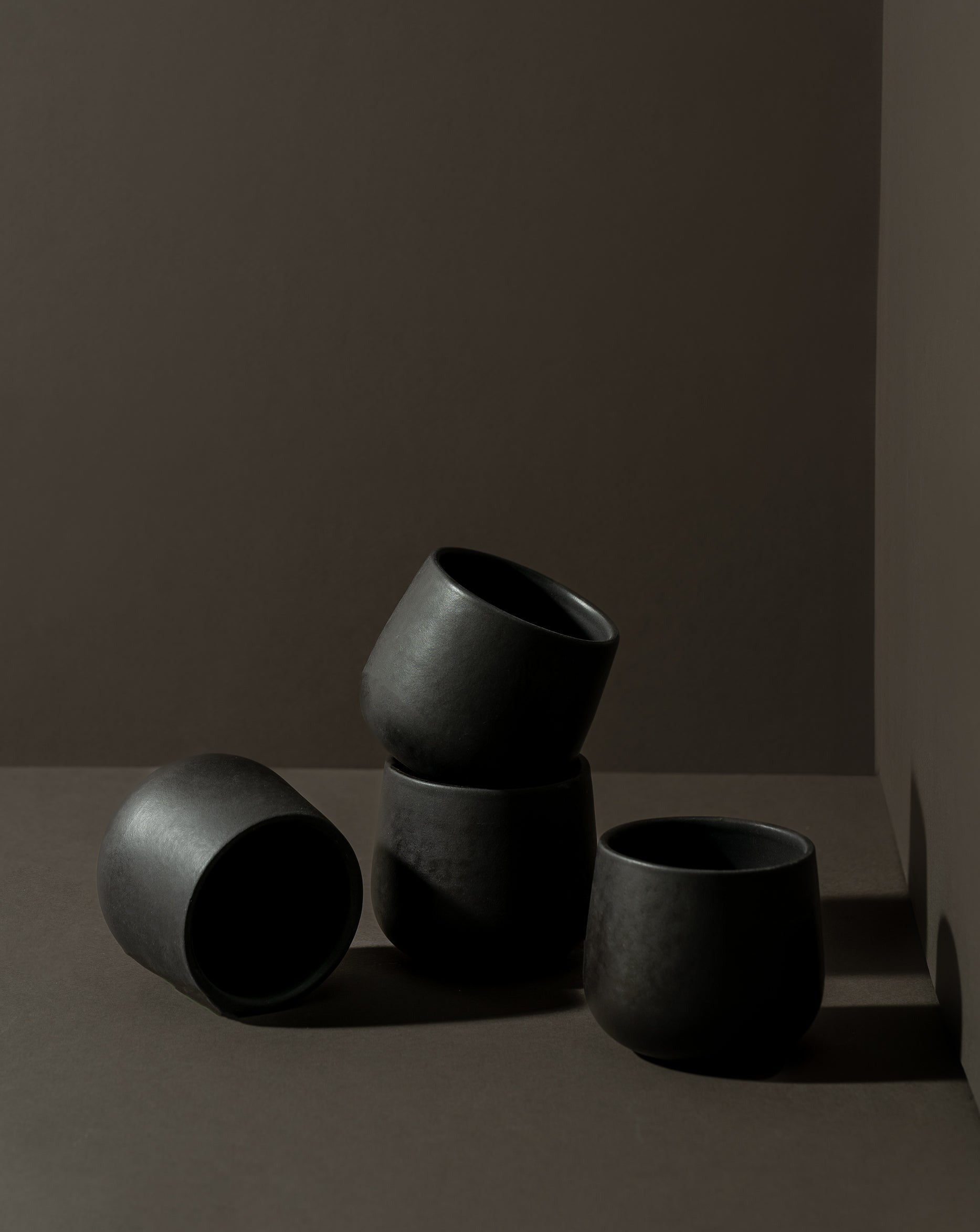 Three stoneware coffee cups in different sizes with a matte finish, displayed against a neutral background.