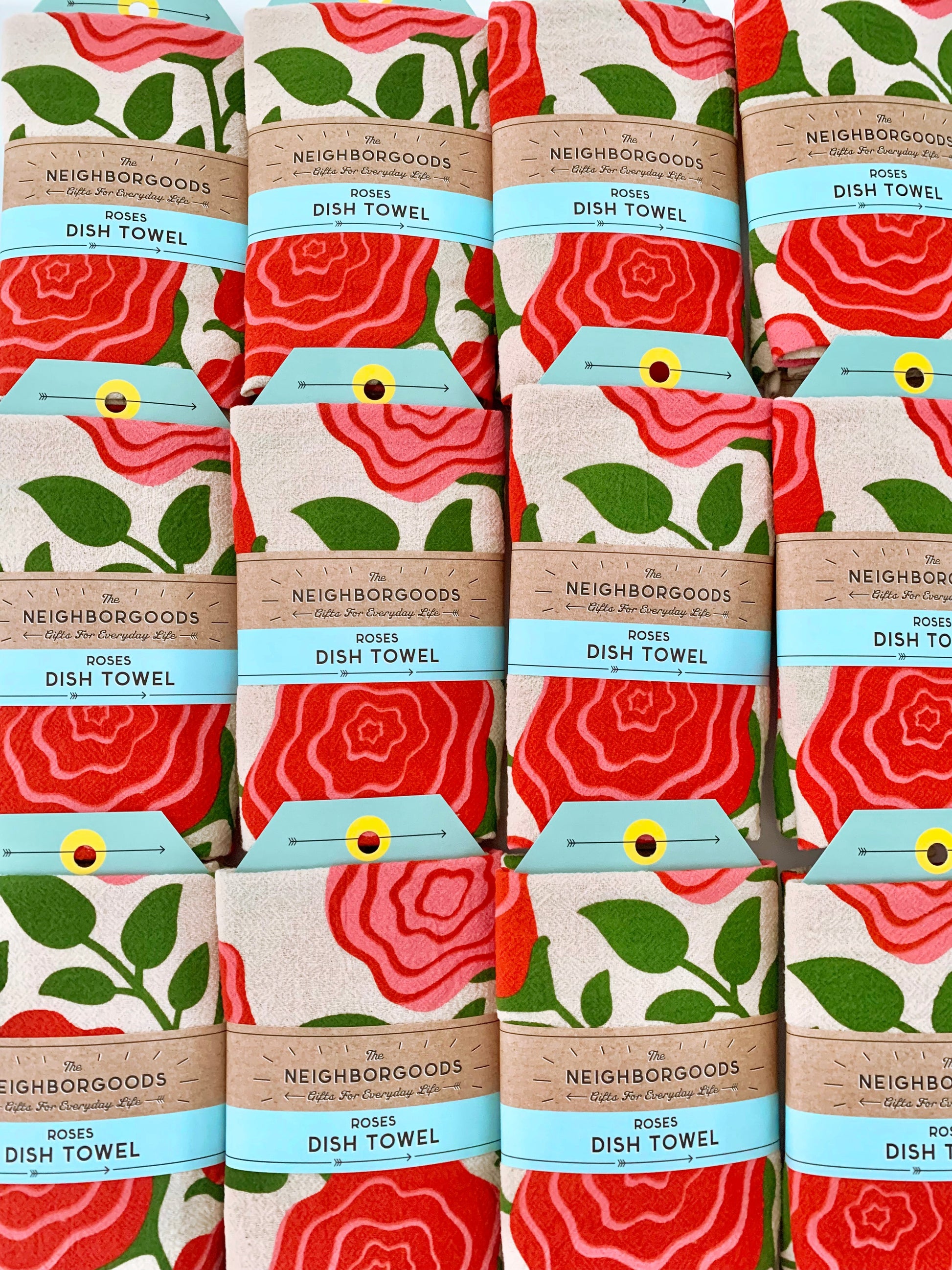 The front view of The Neighborgoods Roses dish towel packaged in ready-to-gift sleeve. 