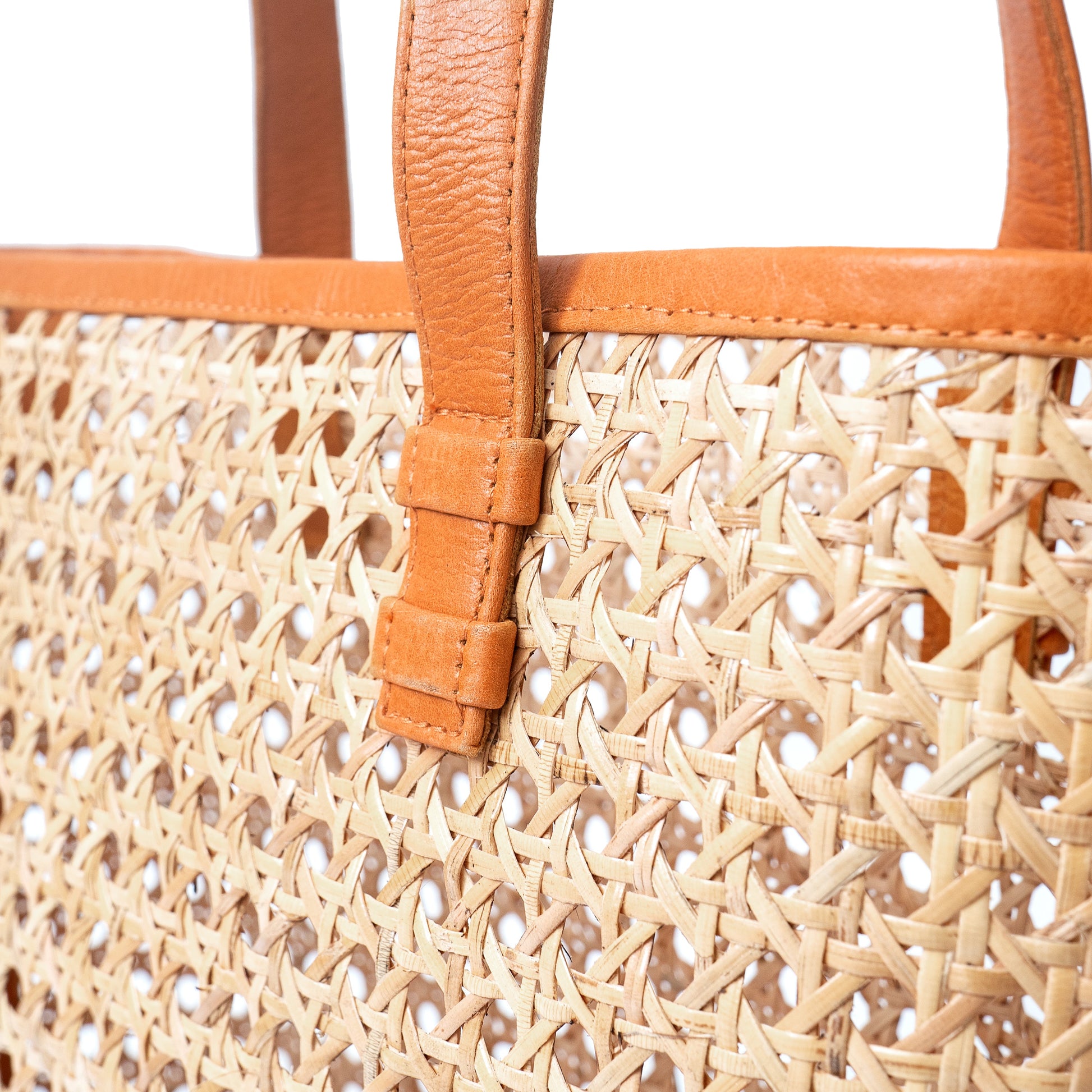 Close up view open weave rattan cane webbing and leather tote shoulder bag