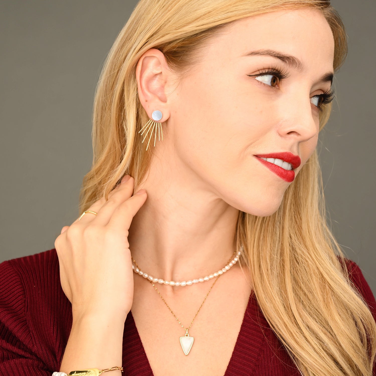 A woman wearing stunning golden and pearl earrings, gold jewelry, Christmas, mother of pearl, popular jewelry brands