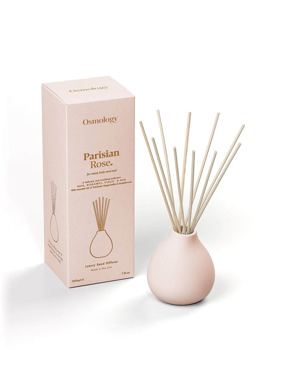 Osmology Parisian Rose pale pink reed diffuser next to product packaging on an orange background