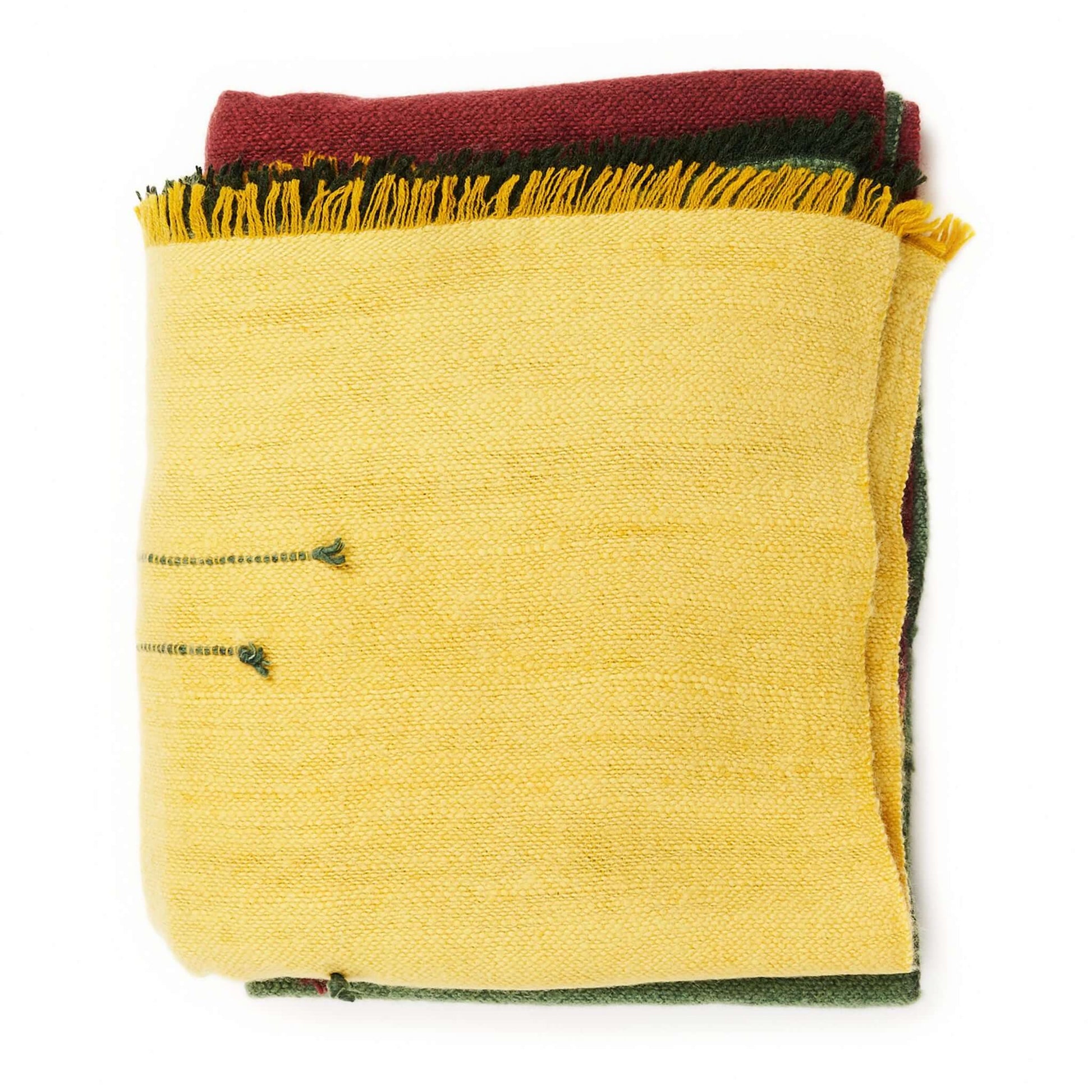 Avocado Green Multi Color Warm Hues Hand Woven Hand Knotted Textured Merino Throw folded and stacked with bold colors.