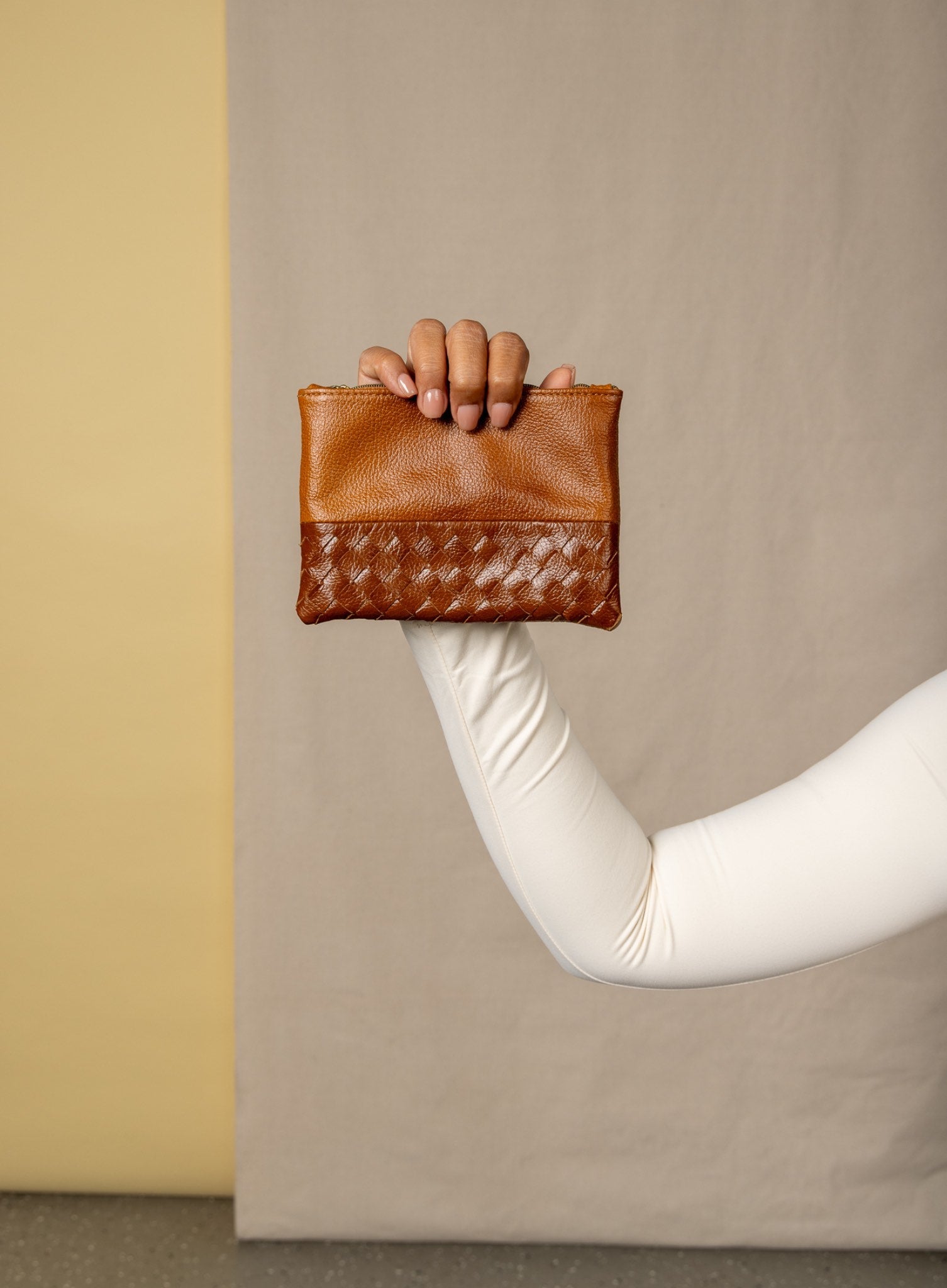 model holding up small pouch in cognac