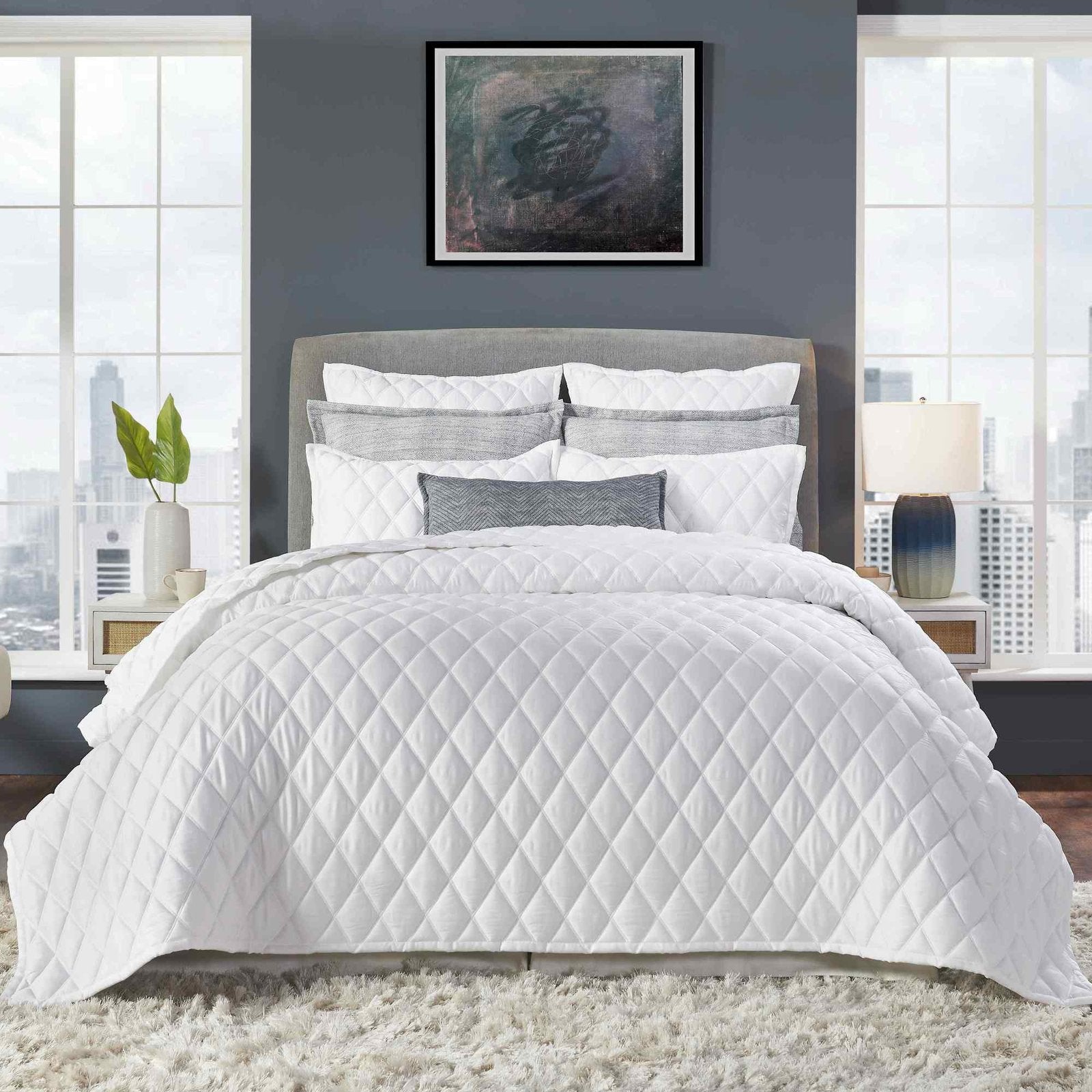 CL-179-X_1|Modern white diamond quilted comforter set with neutral pillows beautifully styled on a bed in urban space.