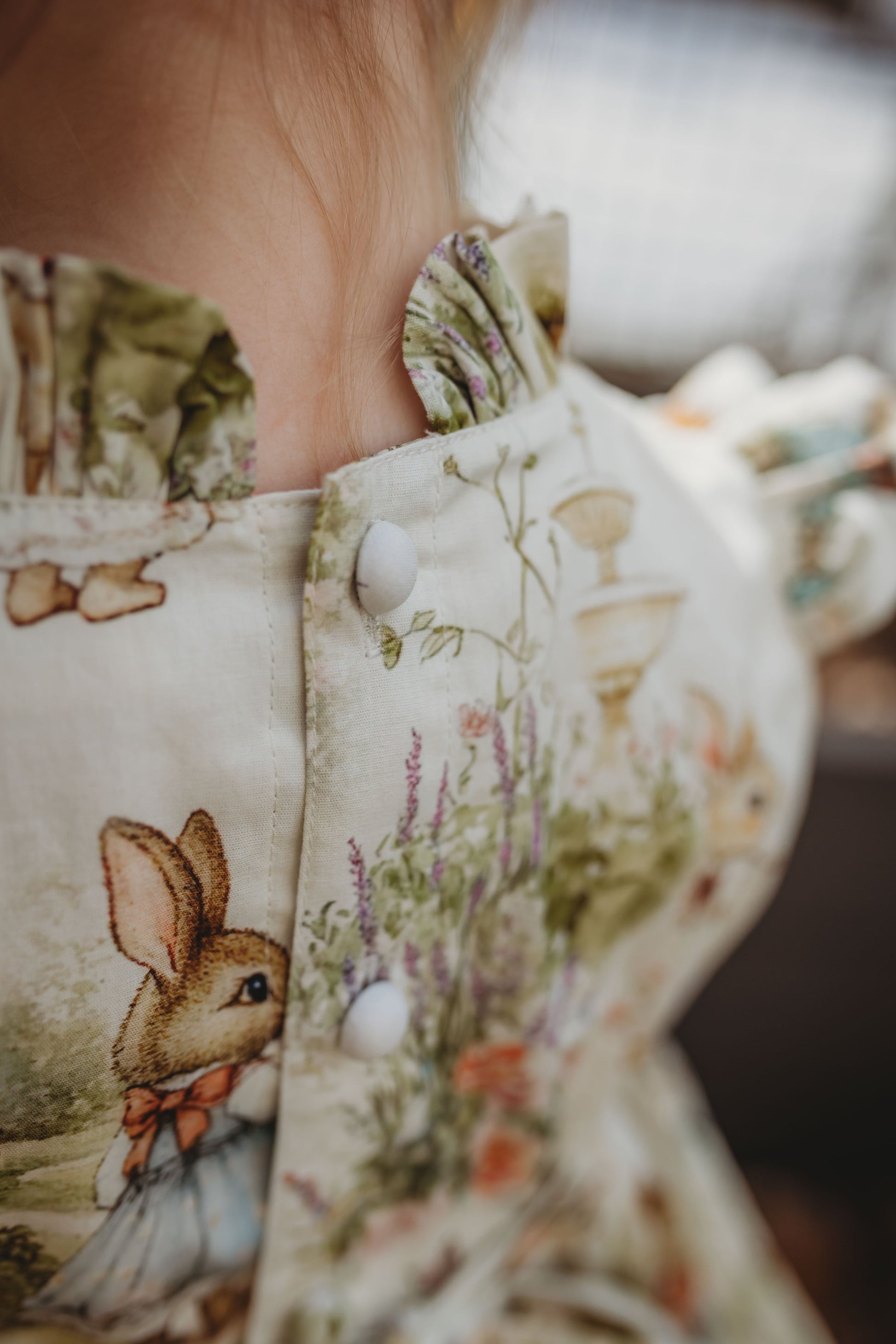 Close-up of a child wearing a floral dress with a rabbit design.