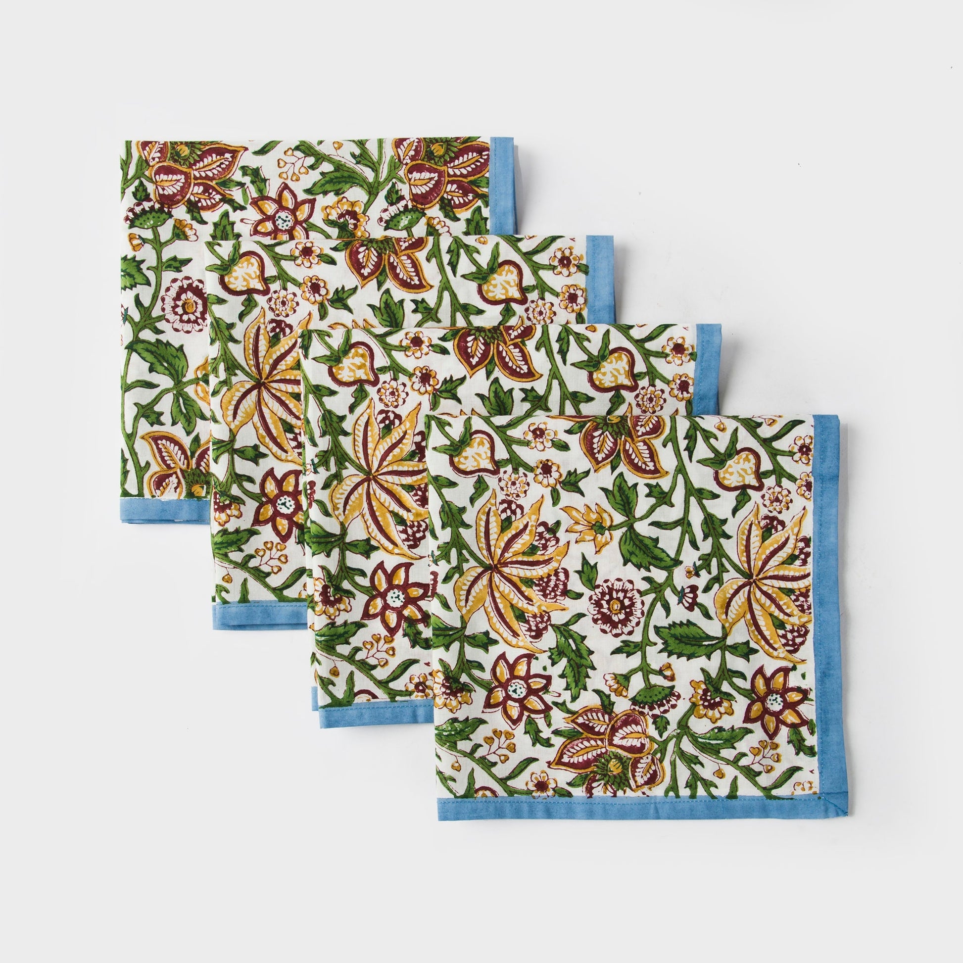Diagonally layered set of 4 blue and green floral block print napkins.