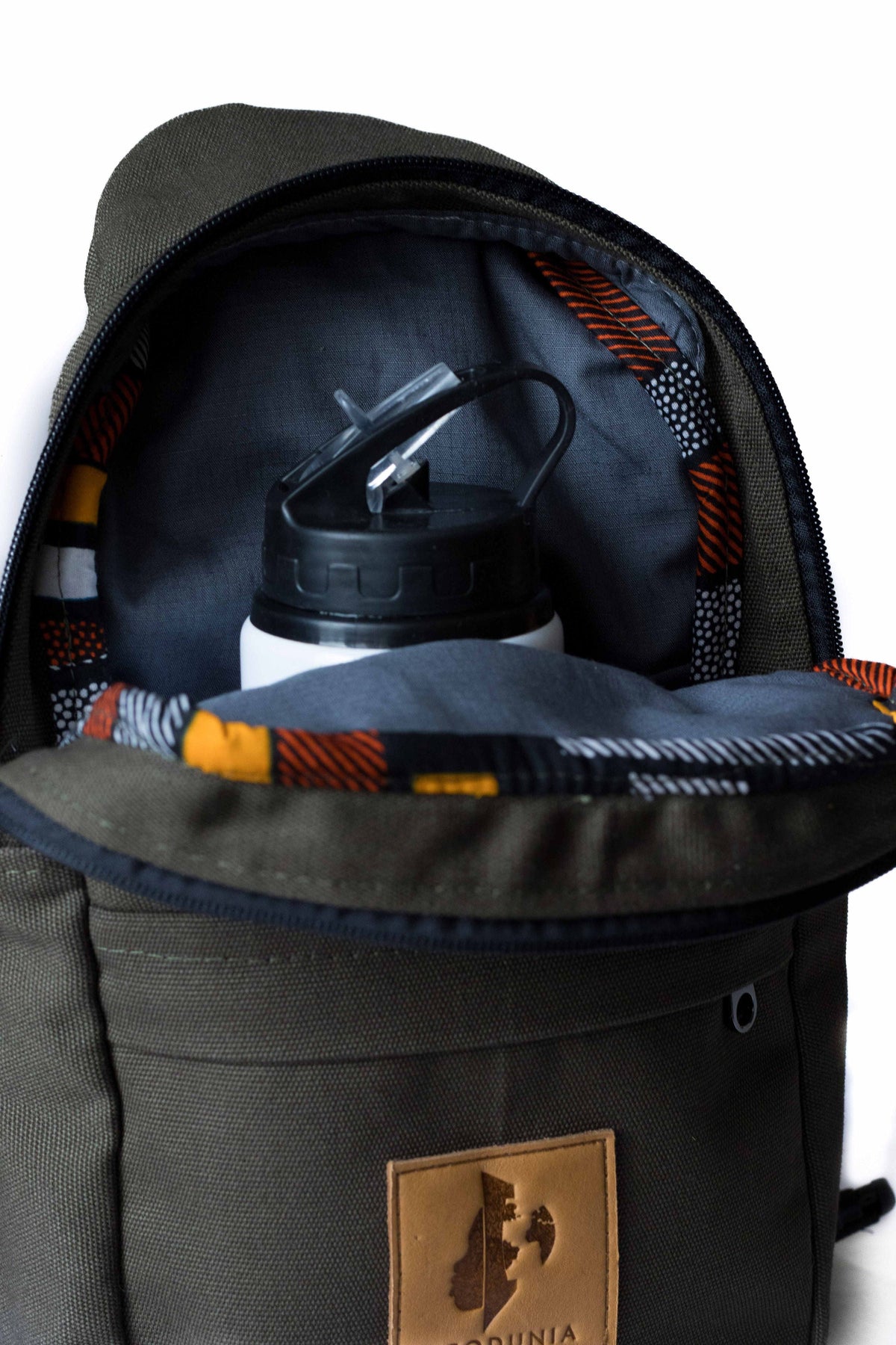 Umoja green canvas sling bag worn hiking #color_green