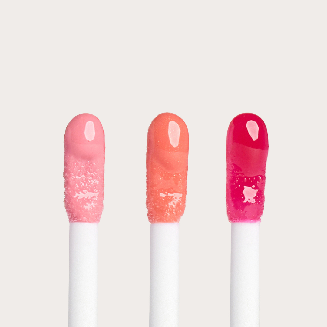 Open applicators of Côte Beauty The Darlings Lip Trio Peptide Non-Toxic Lip Gloss Set in, Light Pink, Coral and Magenta shades. 