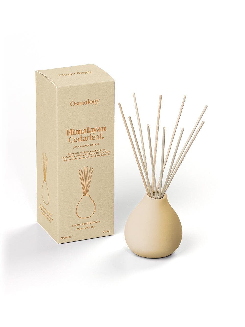 Osmology himalayan cedarleaf ceramic reed diffuser and product packaging on an orange background