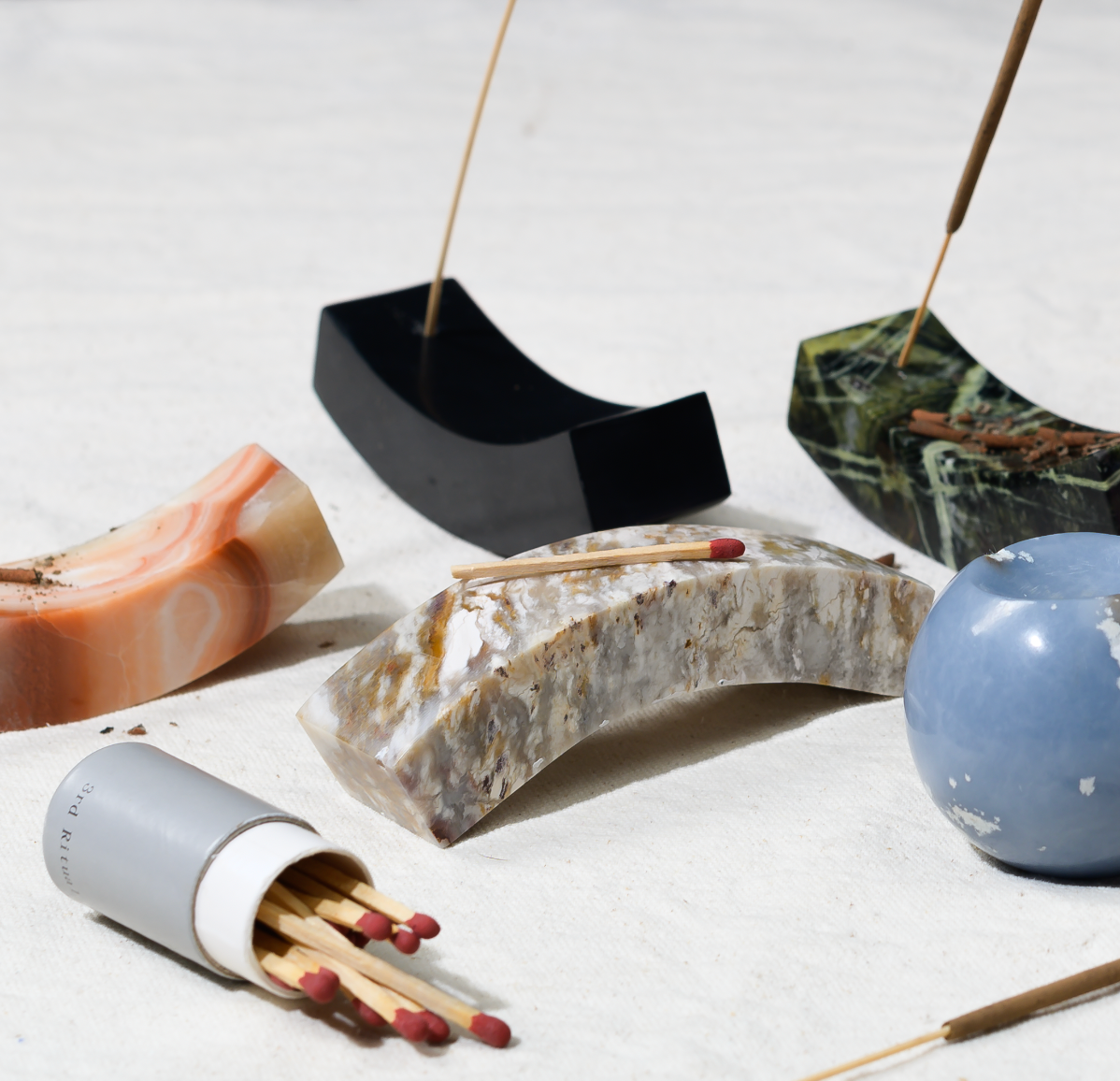 Curated selection of curved stone incense holders serving as elegant wellness and home decor accessories.