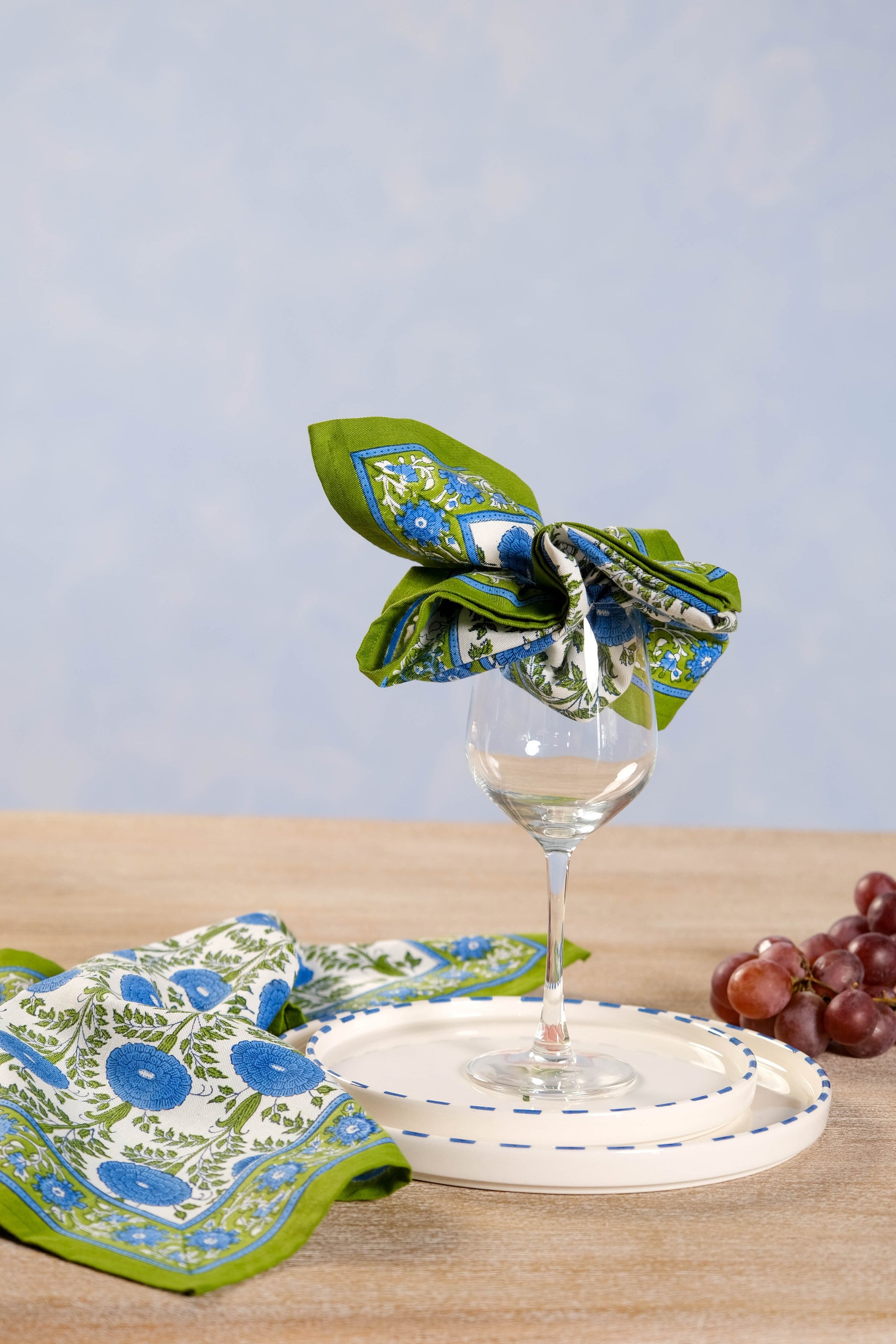 Blue araminta blockprint napkin styled around wine glass on table setting