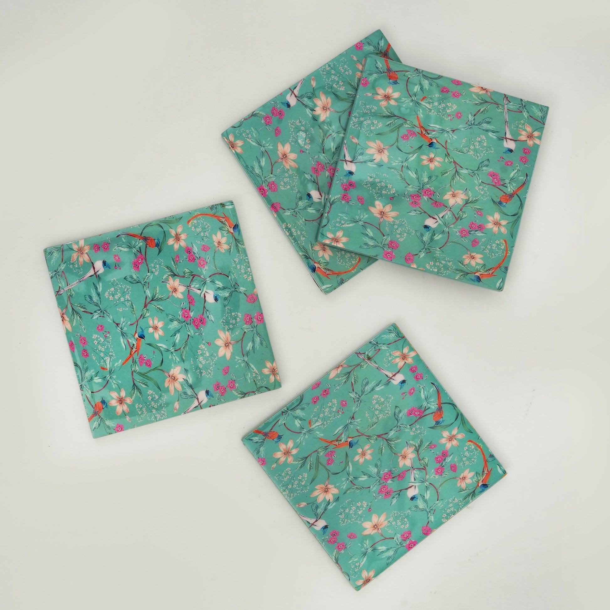 Three floral-patterned coasters on a light gray background