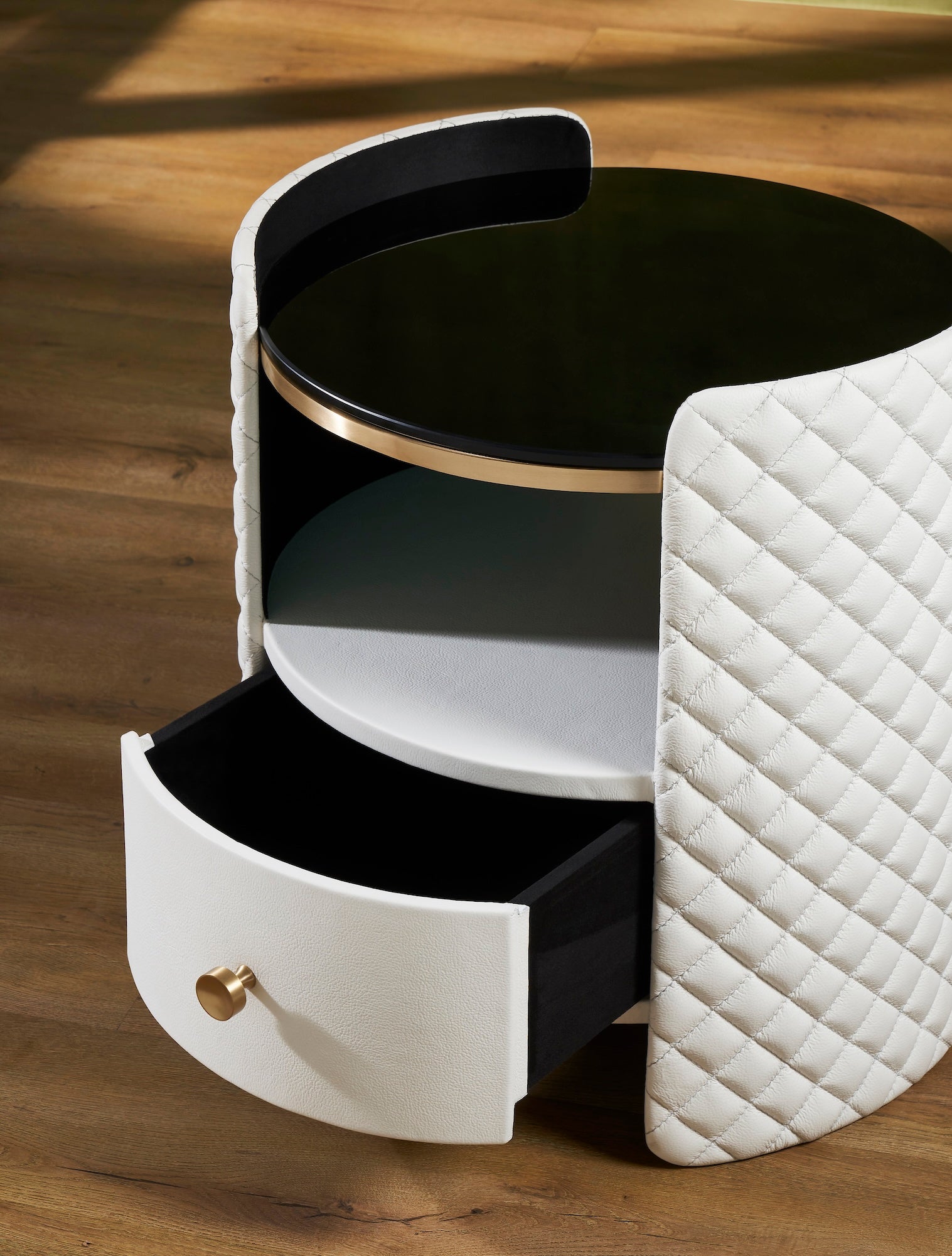 FN-5214-202022_4|Close-up of a white diamond-quilted leather nightstand with a smooth drawer, gold-toned knob, and black glass top.